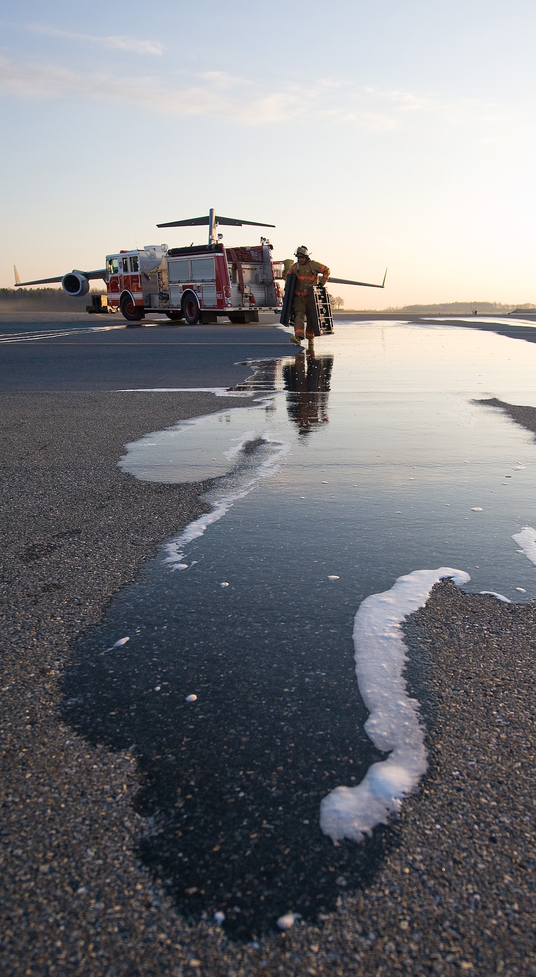 A 436th Civil Engineer Squadron firefighter relocates pallets from his fire truck to another designated area in response to a simulated fuel spill during a Major Accident Response Exercise at Dover Air Force Base April 9. Air Force bases demonstrate and practice their responses to major accidents during MAREs. (U.S. Air Force photo/Tom Randle)
