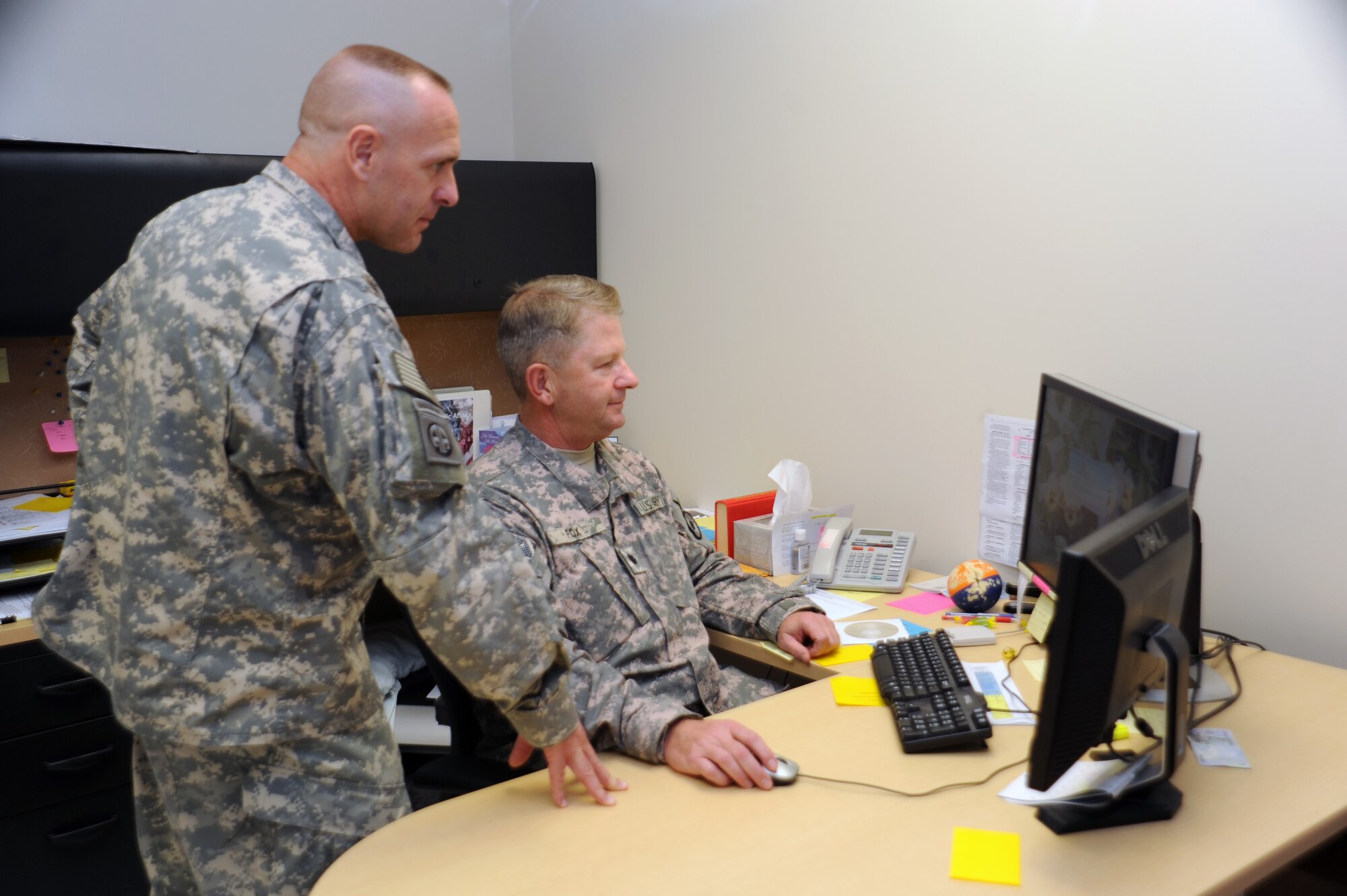Army Ground Liaison Officer, Lt. Col. Scott Mathna researches current ground operations throughout the area of responsibility with his replacement Lt. Col. Craig Fox here April 1. (U.S Air Force photo by Tech. Sgt. Shad Eidson)