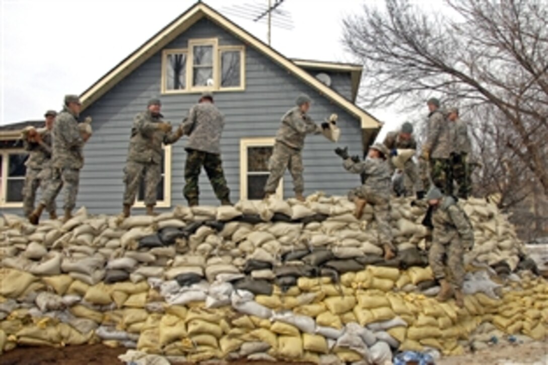 North Dakota National Guard soldiers place sandbags around a house on the banks of the Des Lacs River in Burlington, N.D., April 12, 2009. The soldiers are assigned to the Headquarters Company and Forward Support Company of the 164th Engineer Battalion, Minot; the 957th Multi-Role Bridge Company, Bismarck, and the 818th Sapper Company, Williston.