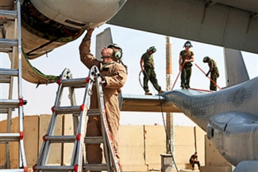 U.S. Marine Gunnery Sgt. William Jankowski, left, inspects an area of the aircraft before it is cleaned on Al Asad Air Base, Iraq, April 4, 2009. Jankowski is a quality assurance chief assigned to Marine Medium Tilt-rotor Squadron 266, which is preparing the aircraft to return to the United States.