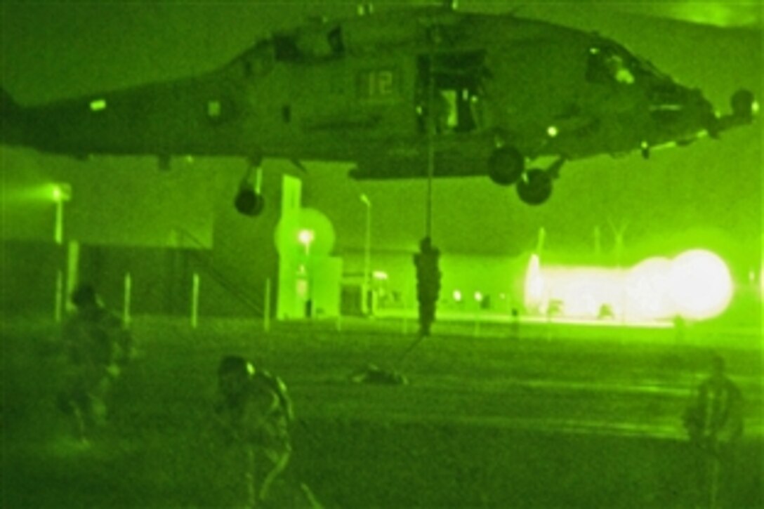 Iraqi Special Operations Forces soldiers hone their fast-roping skills to learn how to slide to the ground, and onto dangerous rooftops after dark during helicopter operations training at Al Asad, Iraq, April 1, 2009. U.S. Special Operations Forces are advising the ISOF soldiers in order to better prepare them for future missions. By using helicopters for insertion, the soldiers will be able to reach objectives much faster in the outlying Al Anbar province than they are currently able to do.