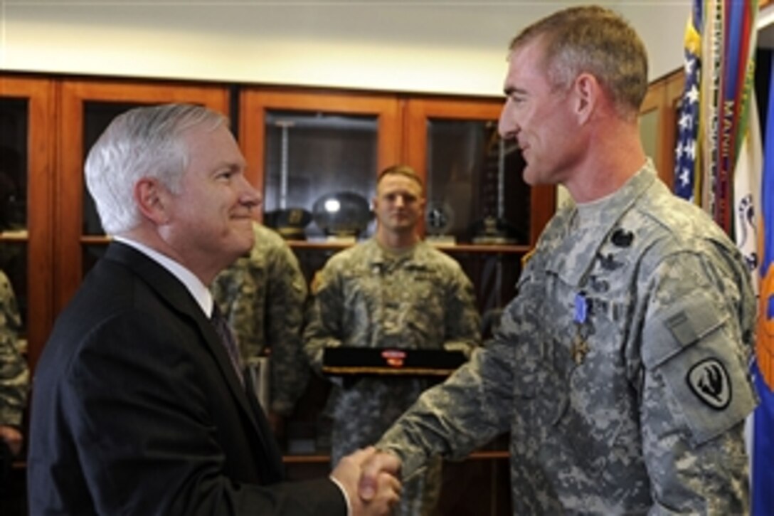 Defense Secretary Robert M. Gates congratulates Chief Warrant Officer 4 Paul F. Druse, Jr. on receiving the Distinguished Flying Cross on Cairns Army Airfield, Ala., April 14, 2009, during a two-day trip to Alabama. 