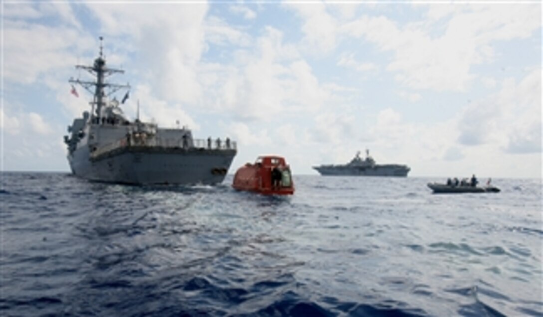 A rigid-hulled inflatable boat maneuvers towards the lifeboat in which Capt. Richard Phillips was held hostage for five days as the amphibious assault ship USS Boxer (LHD 4) stands close by in the Indian Ocean on April 13, 2009. 