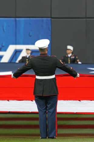 A Marine holds the American Flag across the new Citi Field before the inaugural game for the New York Mets in the stadium, April 13. . (Official U.S. Marine Corps Photo by Sgt. Randall A. Clinton)