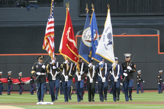 A joint-service color guard marches onto the field as part of the pre-game ceremony for the New York Mets inaugural game at Citi Field, April 13. The Marines unfurled an outfield-sized flag and flew F-18 Hornets overhead to kick-off the season in the new stadium. (Official U.S. Marine Corps Photo by Sgt. Randall A. Clinton)