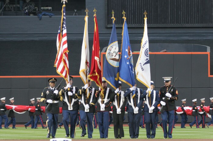 A joint-service color guard marches onto the field as part of the pre-game ceremony for the New York Mets inaugural game at Citi Field, April 13. The Marines unfurled an outfield-sized flag and flew F-18 Hornets overhead to kick-off the season in the new stadium. (Official U.S. Marine Corps Photo by Sgt. Randall A. Clinton)