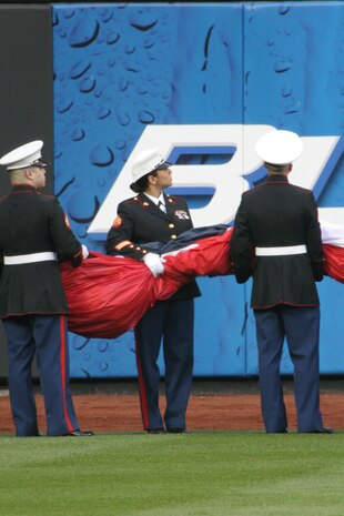 Marines from Marine Aircraft Group 49, 6th Communications Battalion, Recruiting Station New Jersey and 1st Marine Corps District hold an outfield-sized flag before unfurling it across the new home for the New York Mets, Citi Field April1 3. (Official U.S. Marine Corps Photo by Sgt. Randall A. Clinton)