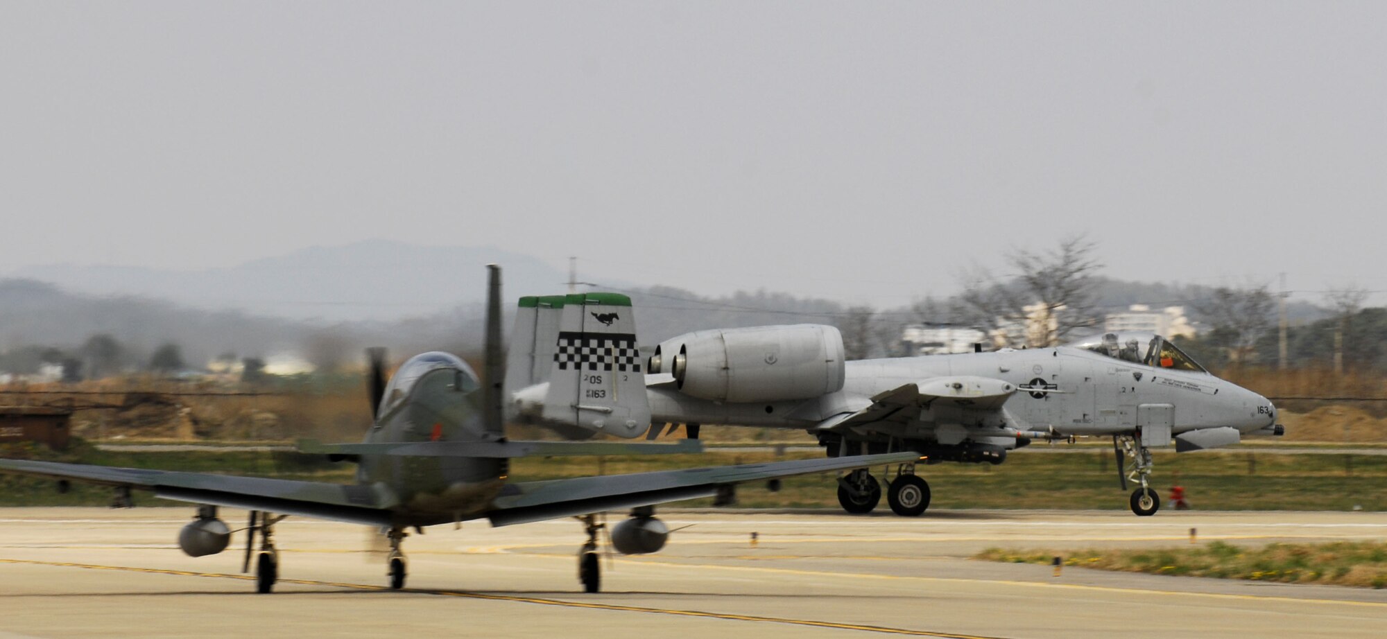 An A-10 Thunderbolt II takes off past a ROKAF KA-1 during the Buddy Wing Program at Osan AB, Republic of Korea on April 14. The 51st Fighter Wing hosted a combined exchange exercise called the Buddy Wing Program this week, with the participation from 25th Fighter Squadron here and Republic of Korea Air Force 15th Composite Wing from Seoul Air Base. The ROKAF aircrew members along with 25 FS trained together in this program allowing both units to introduce tactics and improve interoperability between the U.S. Air Force and the Republic of Korea. (U.S. Air Force photo by Senior Airman Stephenie Wade)