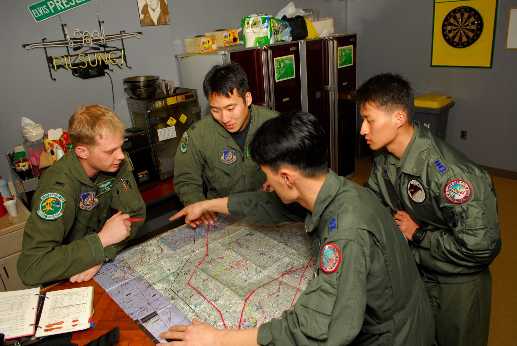 First Lieutenants Mike McCarthy and Al Chang from the 25th Fighter Squadron discuss their flight plans as they prepare for an upcoming mission with Capt. Pak, Chan Mu and Maj. Chong, Hyaon Dong from Republic of Korea Air Forces 15th Composite Wing.  The 51st Fighter Wing hosted a combined exchange exercise called the Buddy Wing Program this week, with the participation from 25 FS here and ROKAF 15 CW from Seoul Air Base. Aircrew members trained together in this program allowing both units to introduce tactics and improve interoperability between the U.S. Air Force and the Republic of Korea.  (U.S. Air Force photo by Senior Airman Stephenie Wade)