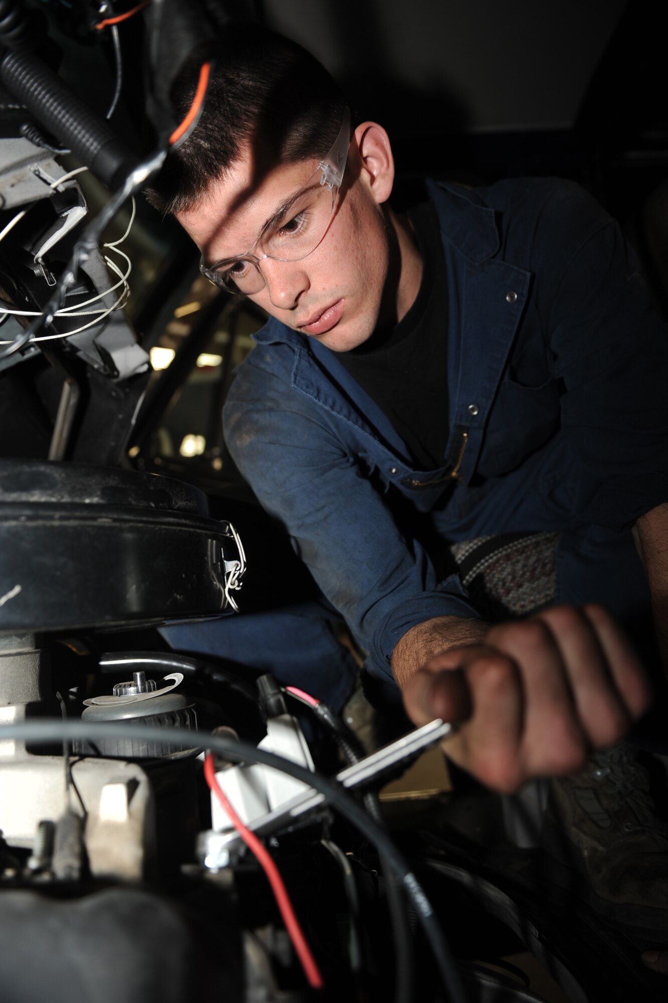 Airman 1st Class Joseph Martincic, 28th Logistics Readiness Squadron vehicle maintenance, tightens a bolt while changing a glow plug controller in a van here, April 14. The glow plug controller regulates voltage to the glow plugs for a specified period of time to assist with cold starts. (U.S. Air Force photo/Airman 1st Class Joshua J. Seybert)