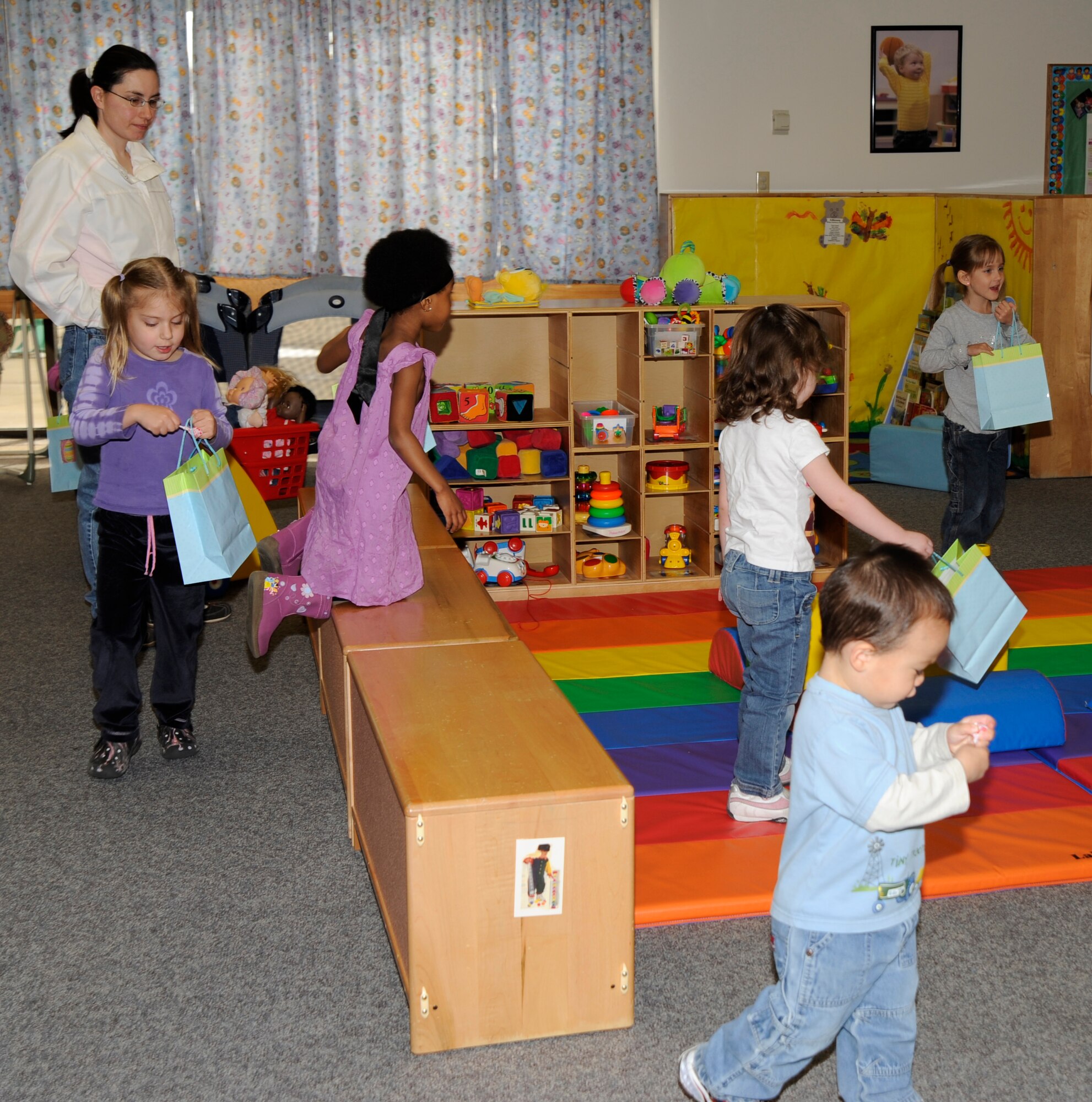 Children search around cubbyholes, niches and other hiding spots searching for Easter eggs during a playgroup Easter party at Bldg. 338, April 10. The children had to hunt for eggs indoor due to the weather, but the playgroup staff accommodated them with extra eggs and candy. (Photo by Airman Justin Shelton) 