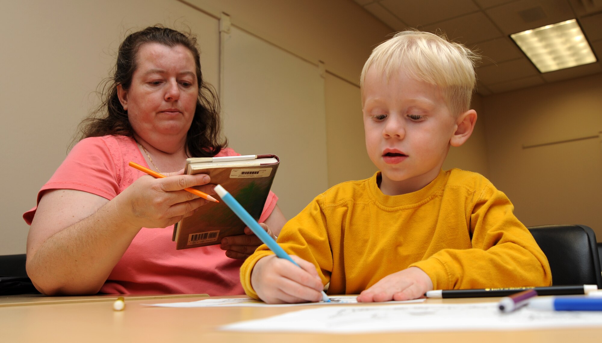Matthew Goodner, 4, son of Master Sgt. Mark Goodner, 22nd Medical Group, colors a picture while mother Madeleine looks over a book her son read during the School Age Book Club held by the McConnell Library, Apr. 10. The School Age Book Club is designed to enhance children’s reading abilities with various activities including reading books, then listening to the audio version while working on crafts. The program is scheduled throughout the school year with supporting programs during the summer. (Photo by Senior Airman Roy Lynch)