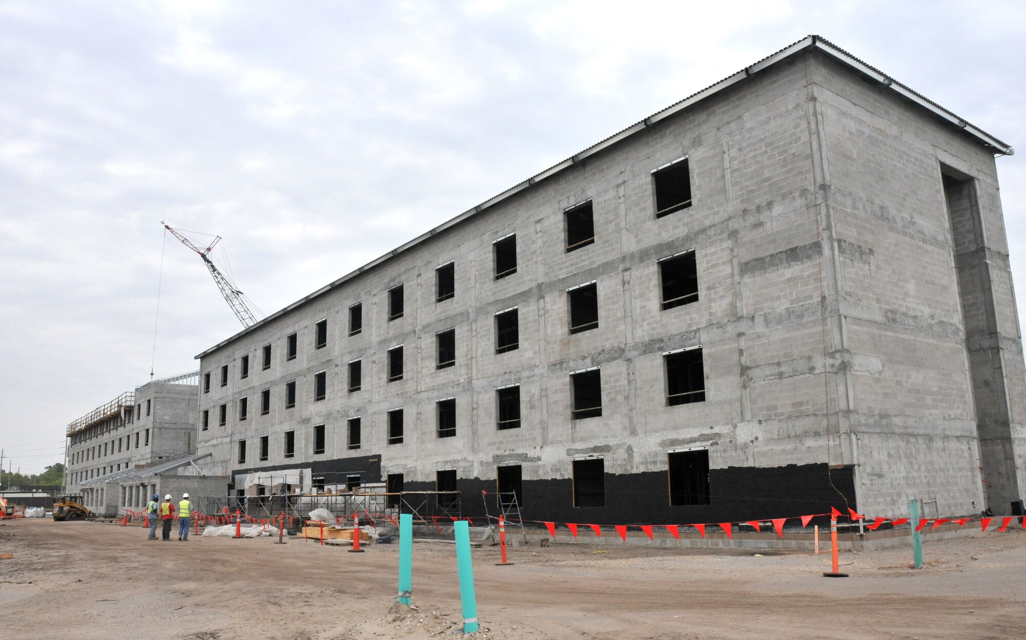 Roof trusses are in place on the dorm’s west end and commons.  Decking has started on the southwest corner.  Metal stud walls on all floors of the west wing are done.  Water lines from the chiller plant are installed and tested, and interior electrical, plumbing, and mechanical rough-ins are under way.  (U.S. Air Force photo by Adam Bond)