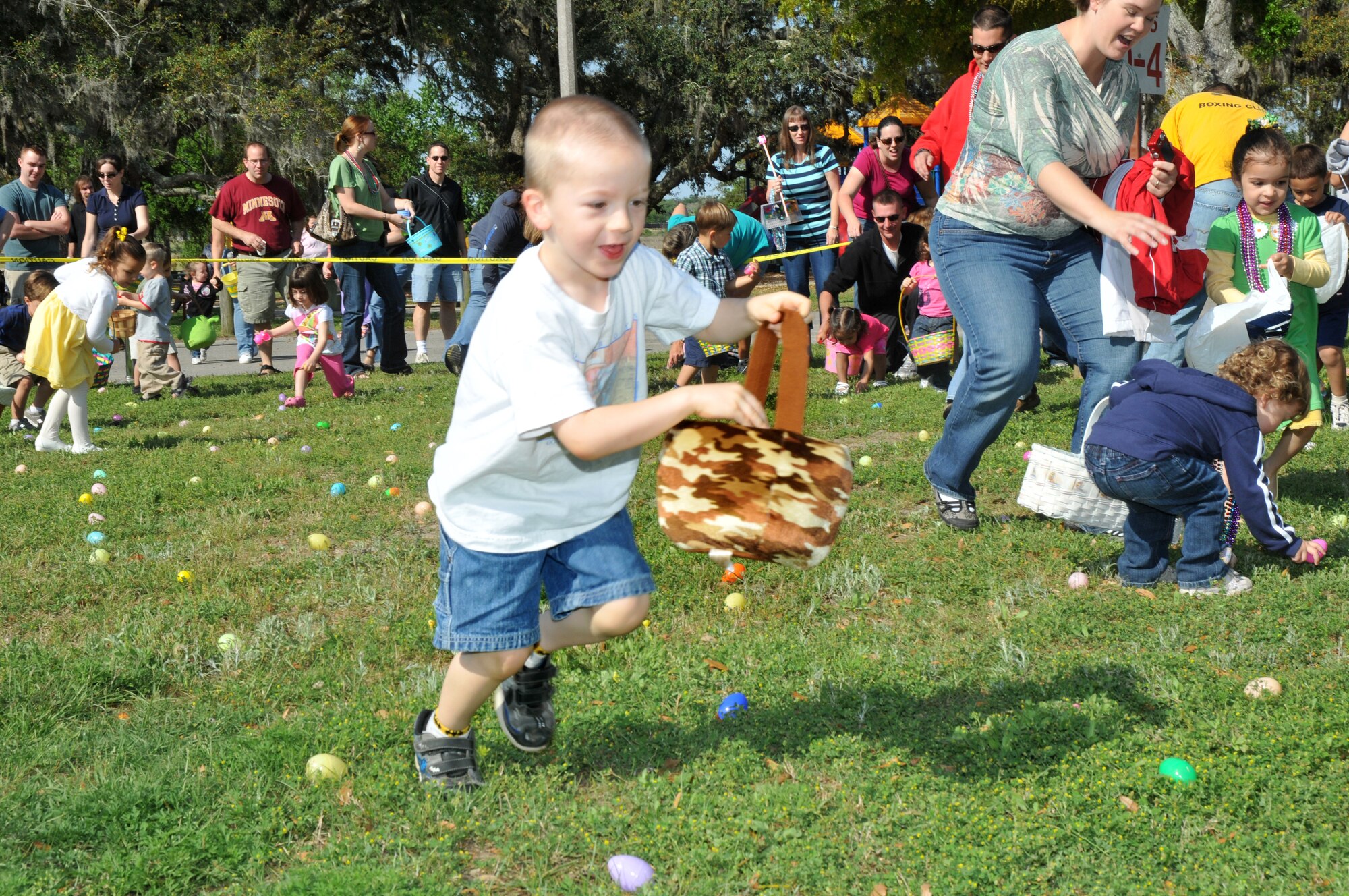 Four-year-old Robert Sheely gathers eggs at Keesler’s annual Easter egg hunt Saturday in marina park..  Robert’s parents are Senior Airman Grant and Lindy Sheely, 81st Medical Operations Squadron. The event, sponsored by Keesler Federal Credit Union, featured more than 5,000 eggs split among three age categories.  An Easter parade preceded the hunt.  (U.S. Air Force photo by Adam Bond)