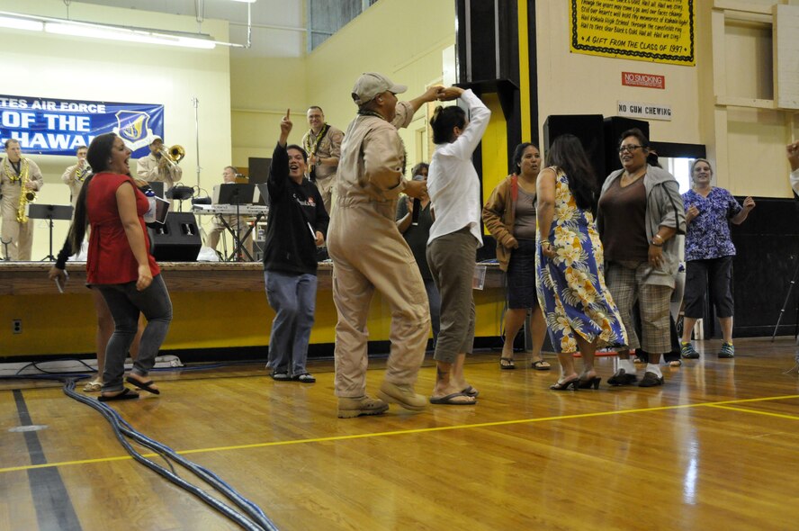 KONA, Hawaii -  U.S. Air Force Band of the Pacific - Hawaii vocalist Staff Sgt. Richard Vasquez, a native of Midland, Texas dances with a crowd participant during a performance at Kohala High School on April 9, as part of a community outreach program. (U.S.  Air Force photo/Tech Sgt. Cohen A. Young)