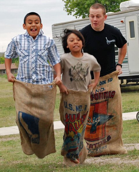 LAUGHLIN AIR FORCE BASE, Texas -- Justin Casarez and Jose Nava III race Airman 1st Class Dennis Reuter, 47th Medical Group, during the Base Easter Egg Hunt festivities, sponsored by the 47th Force Support Squadron, April 11 at the Leaning Pine Golf Course. The races were competitive throughout the day, as youngsters that were able to defeat the winless Airman Reuter received a prize. More than 300 youngsters turned out for the Easter event making it one of the largest held recently, to search for 6,000 Easter eggs, participate in sack races or pony rides. Pinnacle Housing Management provided 800 hot dogs, drinks and sno-cones. The event kicked off with a parade featuring 50 youngsters and their parents marching and riding from the chapel to the golf course, led by a fire truck that had Sparky the Fire Dog and the Easter bunny on-board.(U.S. Air force photo by tech. Sgt. Joel Langton)