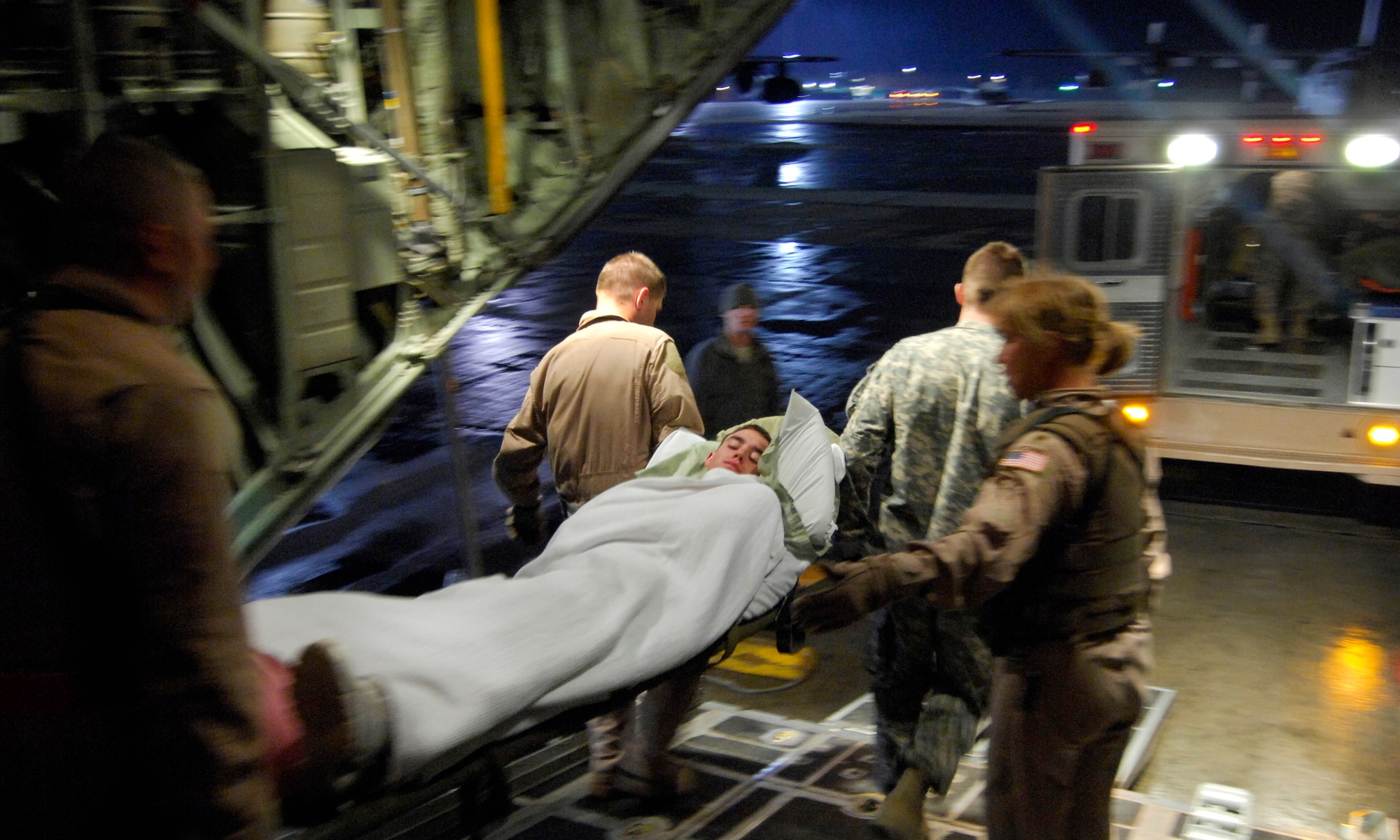 Members of the 455th Aeromedical Evacuation Flight carry Airman 1st Class Brent Noah to an ambulance at Bagram Airfield, Afghanistan, March 26.  Airman Noah, assigned to the 376th Expeditionary Aircraft Maintenance Squadron at Manas Air Base, Kyrgyzstan, dislocated his hip and was being flown to Bagram Airfield for treatment.  (U.S. Air Force photo/Senior Airman Erik Cardenas)