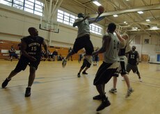 Edric Byrd jumps to block a shot by Adam Konstanzer as Joseph Truesdale,14, and Errol Samuel,15 , wait for the rebound during the intramural basketball game at the Fitness and Sports Center April 14. SFS beat OSS 39 - 34. Byrd and Truesdale are assigned to the 437th Operations Support Squadron. Konstanzer and Samuel are assigned to the 437th Security Forces Squadron. (U.S. Air Force photo/Senior Airman Timothy Taylor)