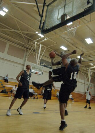 Darren Claverie, left, waits for a rebound as Errol Samuel, right, attempts to block a shot by Joseph Truesdale during the intramural basketball game at the Fitness and Sports Center April 14. SFS beat OSS 39 - 34. Claverie and Samuel are assigned to the 437th Security Forces Squadron. Truesdale is assigned to the 437th Operations Support Squadron. (U.S. Air Force photo/Senior Airman Timothy Taylor)