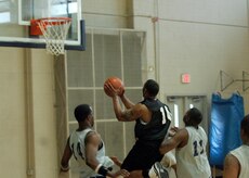 OSS defenders Joseph Truesdale, left, and Edric Byrd, right, try to block Greggery Gordon as he shoots the ball during the intramural basketball game at the Fitness and Sports Center April 14. SFS beat OSS 39 - 34. Truesdale and Byrd are assigned to the 437th Operations Support Squadron. Gordon is assigned to the 437th Security Forces Squadron. (U.S. Air Force photo/Senior Airman Timothy Taylor)
