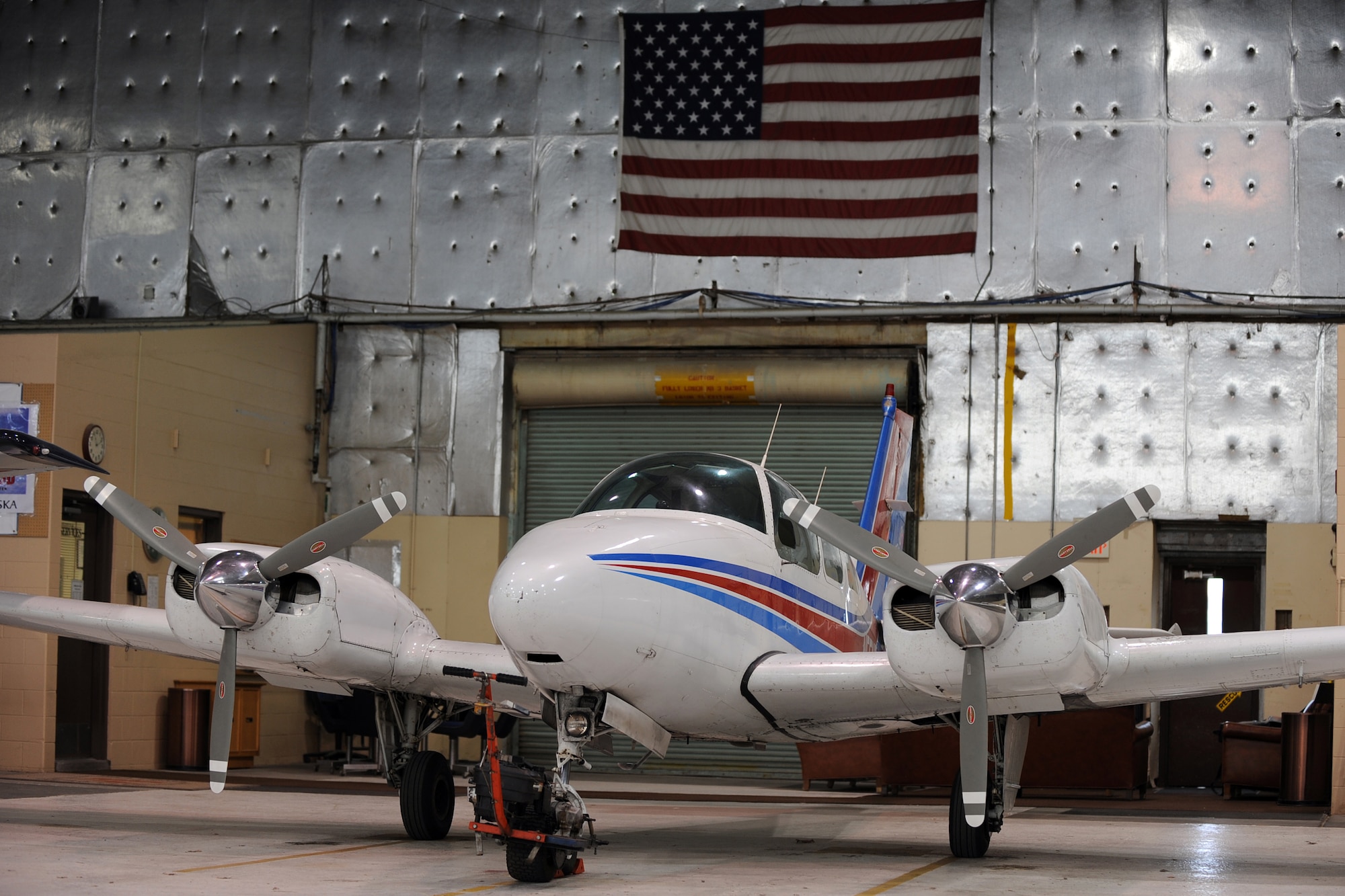 OFFUTT AIR FORCE BASE, Neb. - A BE-55 Baron sits in front of an American flag at the LeMay Aero Club hangar.  The Baron is one of 11 aircraft aspiring pilots can learn how to fly at the aero club.  U.S. Air Force Photo by Josh Plueger