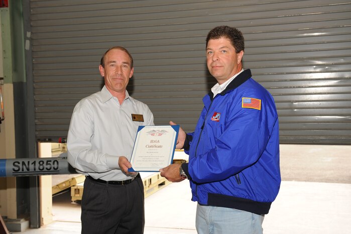 Jeffrey Ayala (left), Nellis Innovative Development Through Employee Awareness (IDEA) Program manager, presents Chad Russ, Nellis pod shop manager, with an IDEA Program certificate April 14, at Nellis Air Force Base, Nev. Mr. Russ’ idea of improving the maintenance procedures for the Nellis Air Combat Training System (NACTS) pods, was approved and will be implemented Air Force wide. This idea will save Nellis and the Air Force more than $230,000 to locally repair the nose cones of NACTS pods. NACTS pods are used during Red Flag and Green Flag exercise and are used to track aircraft activity and data , such as angle of attack information, air speed and provide a cockpit view. 
(U.S. Air Force photo by Airman 1st Class Brett Clashman)

