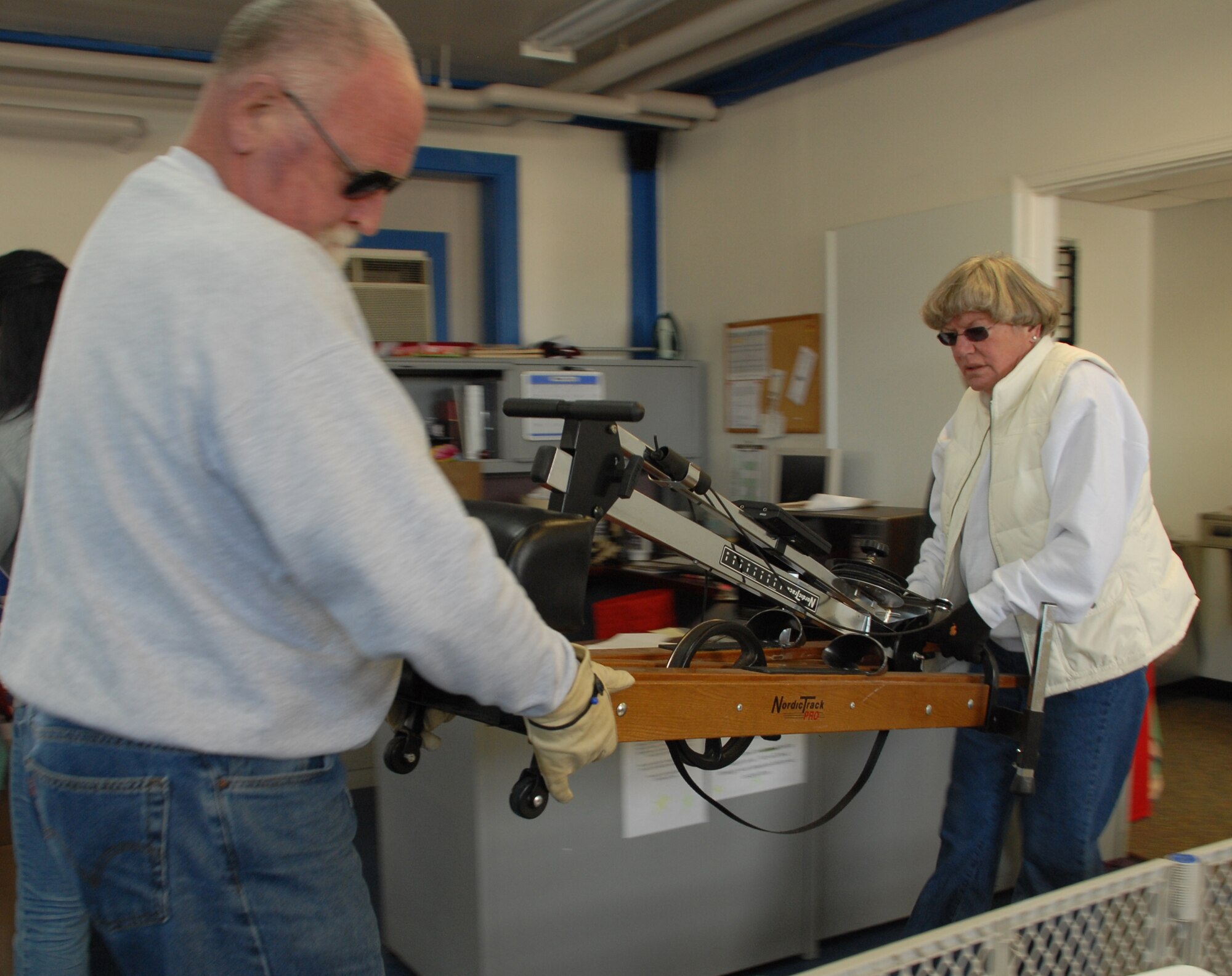 (Left to right) Army (ret.) Master Sgt. Sam Price and wife, Bobby, brings an exercise machine, along with several other items, to donate to the Airman's Attic. The Airman's Attic is a volunteer-run base organization that offers Dover Airmen and their families new and used donated items. (U.S Air Force photo/Airman 1st Class Shen-Chia Chu)
