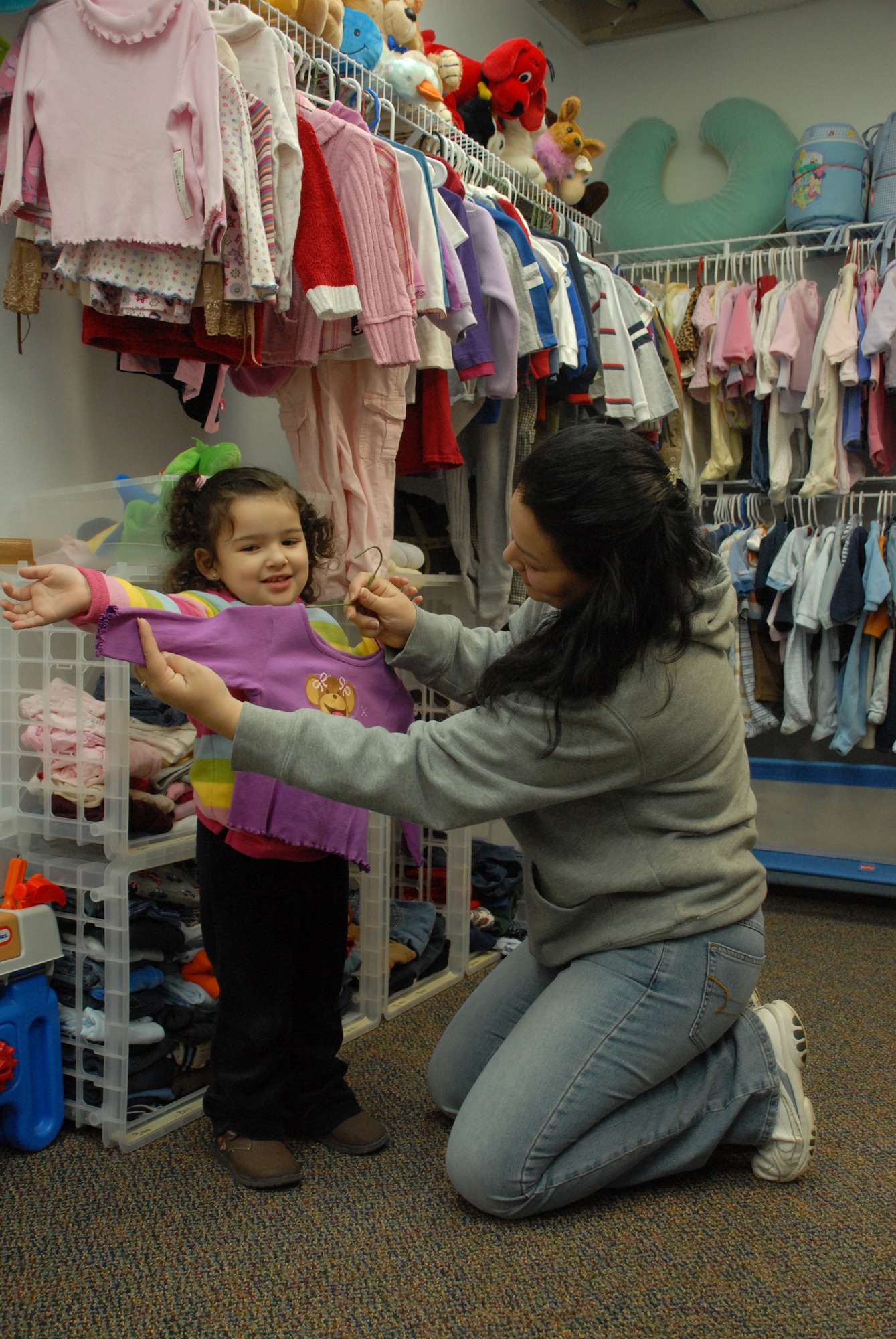Danitza Desouza, wife of Senior Airman Antonio Desouza, 436th Security Forces Squadron, picks new and used clothes for her daughter, Camila Desouza, at the Airman's Attic. The Airman's Attic is a volunteer-run base organization that offers Dover Airmen and their families new and used donated items. (U.S Air Force photo/Airman 1st Class Shen-Chia Chu)