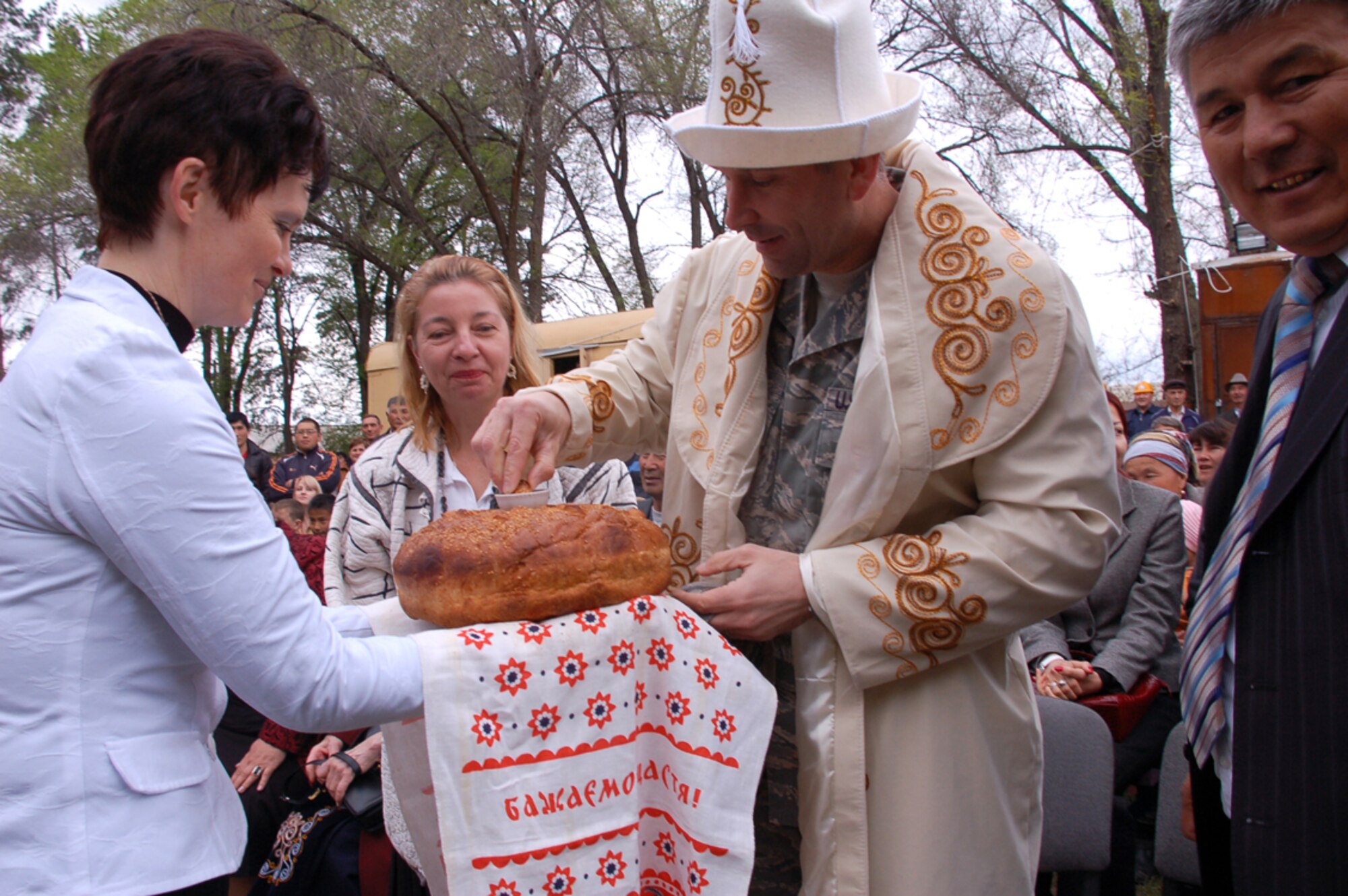 During the Birdik Village School ground-breaking ceremony, April 14, Principal Olga Voroshihina shares homemade bread, called nan, with the U.S. Ambassador to Kyrgyzstan Tatiana Gfoeller, Manas Air Base commander Col. Christopher Bence, and Birdik Village Mayor Syrgak Kydykeev. The distinguished visitors broke bread to symbolize peace and prosperity and good progress for a $470,000 project the United States has undertaken to renovate the 200-student school in the Kyrgyz Republic. (U.S. Air Force photo/Tech. Sgt. Phyllis Hanson)