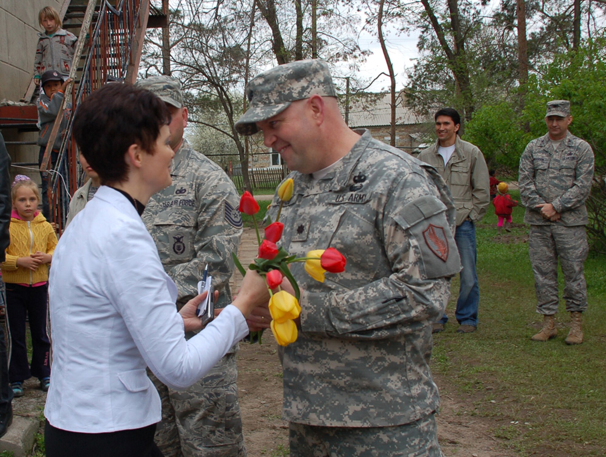 During a ground-breaking ceremony held April 14 for a renovation project at Birdik Village School in Kyrgyzstan, Olga Voroshihina, the school?s principal, gives freshly picked tulips to Lt. Col. Patrick Crabb, chief of the U.S. Embassy's Office of Military Cooperation, to thank him for his unwavering efforts over the past several years to secure funding for a $470,000 school renovation project and help ensure it became a reality. Scheduled for completion in Autumn 2009, the renovated school will house 200 students. (U.S. Air Force photo/Tech. Sgt. Phyllis Hanson)