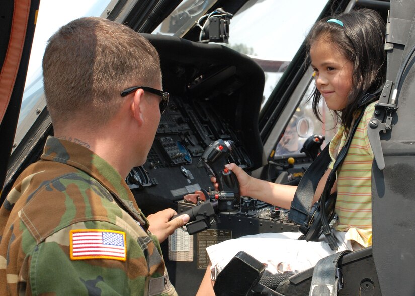 SOTO CANO AIR BASE, Honduras - Army Sergeant Clayton Peterson, 1-228th Aviation Regiment, shows Angie Aviles, 8, the cockpit of a UH-60 Blackhawk helicopter during a Honduran air show in Tegucigalpa, April 14.  Sergeant Peterson is a flight medic assigned to Joint Task Force-Bravo here.  As a flight medic, Sergeant Peterson is responsible for providing life-saving medical care in the event of an in-flight emergency among other things.  (U.S. Air Force photo/Tech. Sgt. Rebecca Danét) 