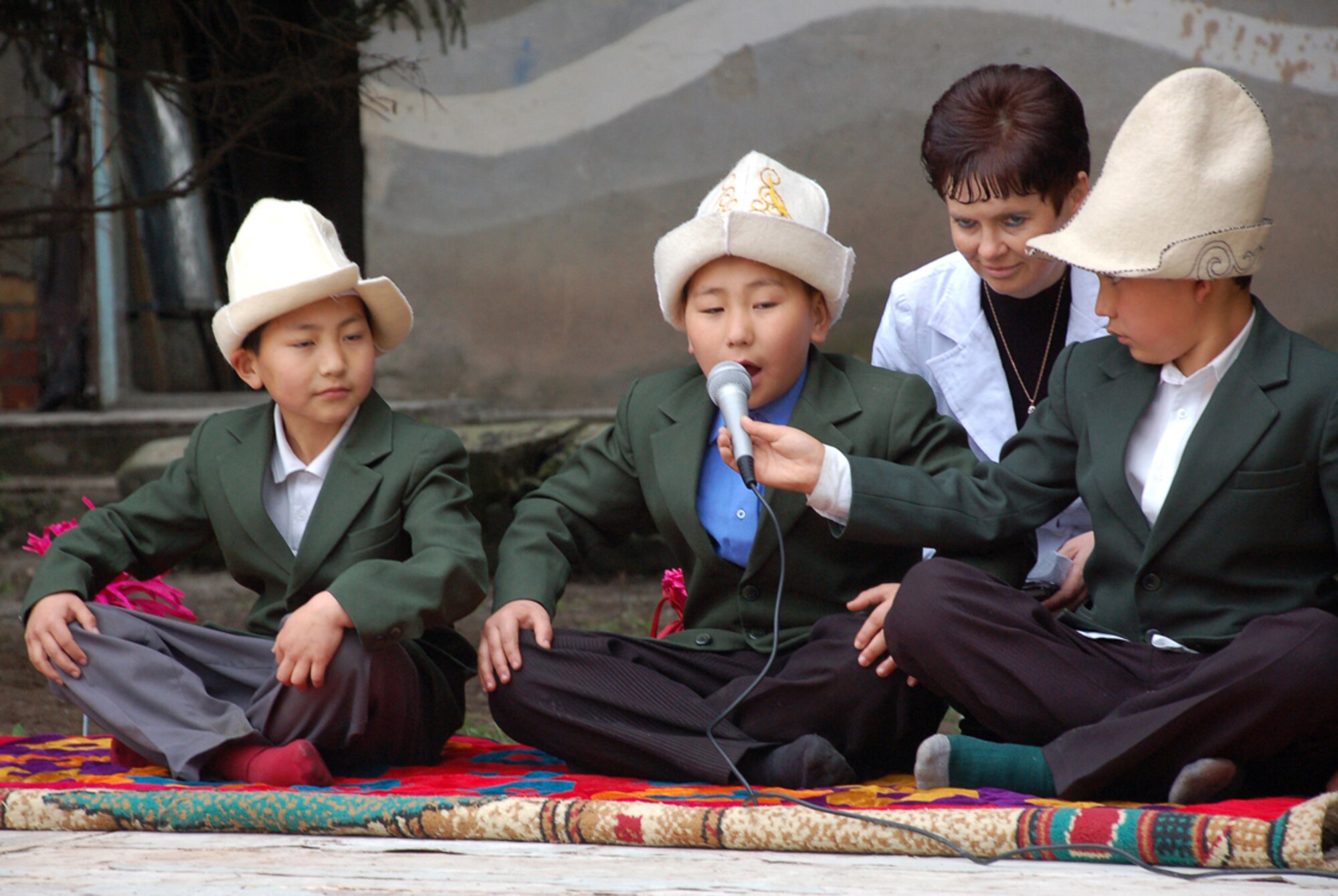 During a ground-breaking ceremony held April 14 for a renovation project at Birdik Village School in the Kyrgyz Republic, Kyrgyz students and their principal, Olga Voroshihina, recite excerpts from the famous Epic of Manas poem. Nearly a month after work began on the $470,000 project to repair the school, a ceremony was held to recognize the development partnership between the U.S. State Department, U.S. Central Command, Manas Air Base and Birdik Village. (U.S. Air Force photo/Tech. Sgt. Phyllis Hanson)