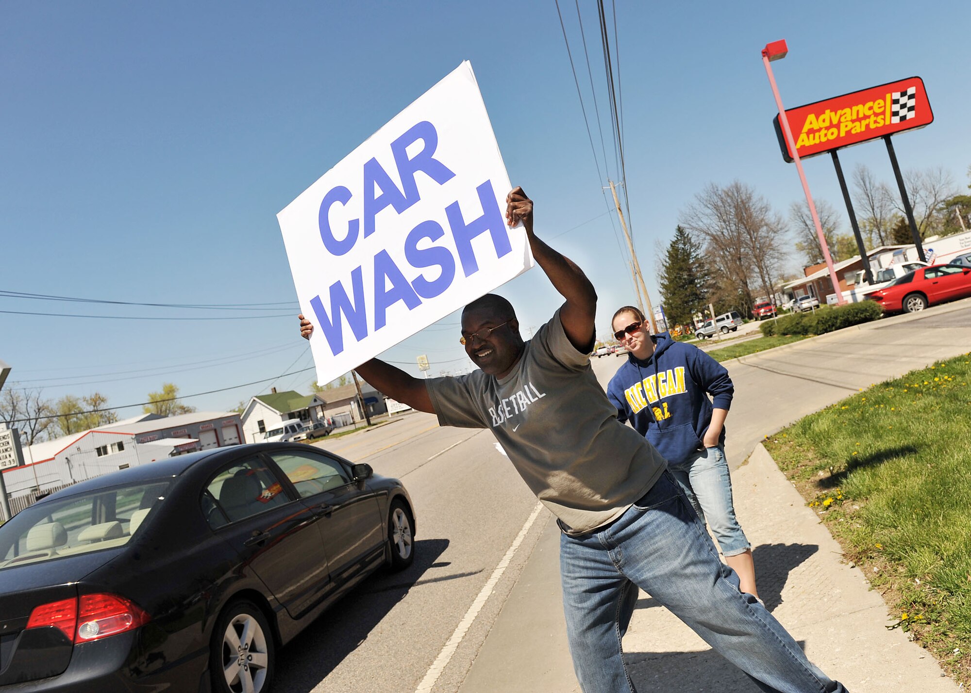 SCOTT AIR FORCE BASE, Ill. --Tech. Sgt. Juan Ives and Senior Airman Christina Johnson of the 375th Aeromedical Evacuation Squadron signal drivers into an Air Force Ball fundraiser car wash in Fairview Heights Saturday. The car wash is one of many different events planned to help offset ticket prices for the 2009 Air Force Ball, scheduled for Sept. 12 at the Scott Club. The committee’s goal is to get the price down to $25 per ticket--half the price of last year’s event. Some other planned fundraising events include Cardinal’s games, bowling tournaments and golf tournaments. The theme of this year’s event is "The Year of the Tanker."(U.S. Air Force photo/Senior Airman Megan Gilliland)