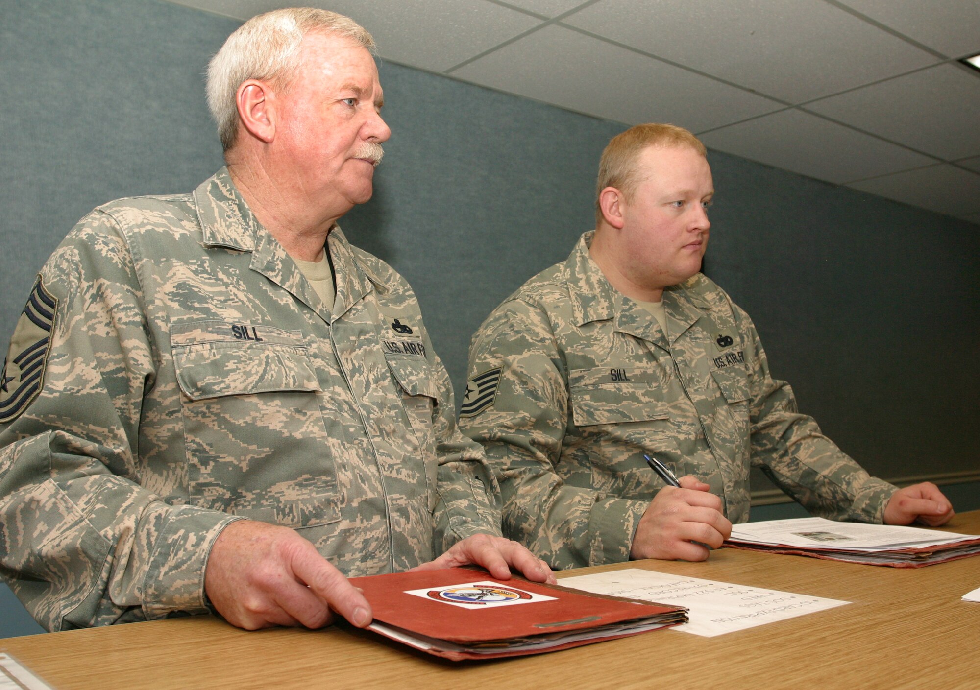 Chief Master Sgt. David Sill, senior Air Reserve Technician for the 419th Fighter Wing's 67th Aerial Port Squadron, and his son, Tech. Sgt. Nicholas Sill, an Air Transportation Craftsman in the same squadron, outprocess together for their deployment to Iraq. (U.S. Air Force photo/Staff Sgt. Kyle Brasier)