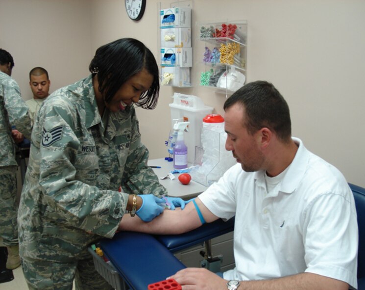 SHAW AIR FORCE BASE, S.C. - Staff Sgt. Wescott performs a phlebotomy procedure, a procedure more commonly known as 'drawing blood,' on Tech. Sgt. Bisignano for his annual PHA. This is the typical experience for most people who come to the lab. (U.S. Air Force photo/2nd Lt. Emily Chilson)