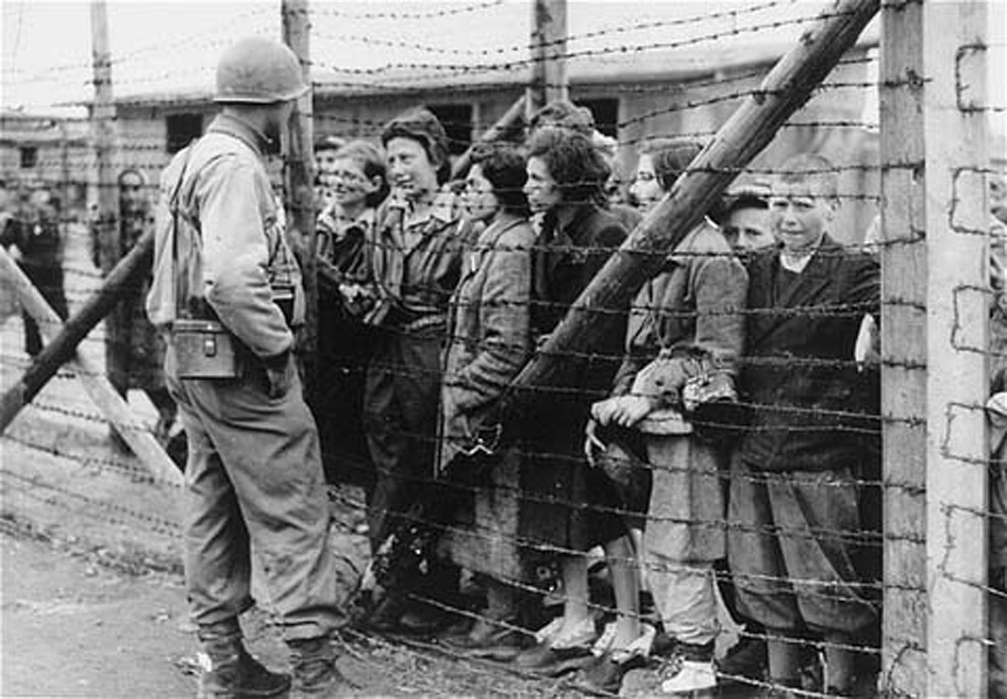 Women and children survivors in Mauthausen speak to an American liberator through a barbed wire fence. Mauthausen, Austria. May 05, 1945-May 07, 1945.
USHMM, National Archives and Records Administration (courtesy photo)