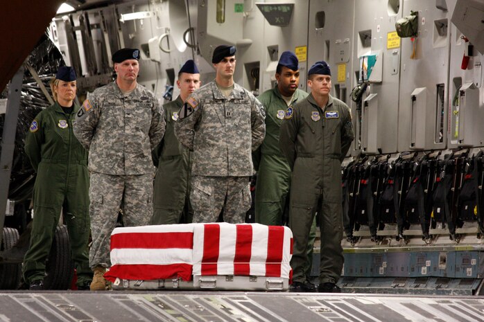 Members of the 14th Airlift Squadron and the Army wait to render honor to the  body of Spc. Israel Candelaria Mejias at Dover AFB., Del., April 7. The 14 AS crew was tasked with bring the remains of Specialist Mejias back to the U.S. where his body was prepared by the Air Force Mortuary Affairs Operation Center for final travel to San Lorenzo, Puerto Rico. (Photos by Leo Shane III. Used with permission from the Stars and Stripes. © 2009 Stars and Stripes)