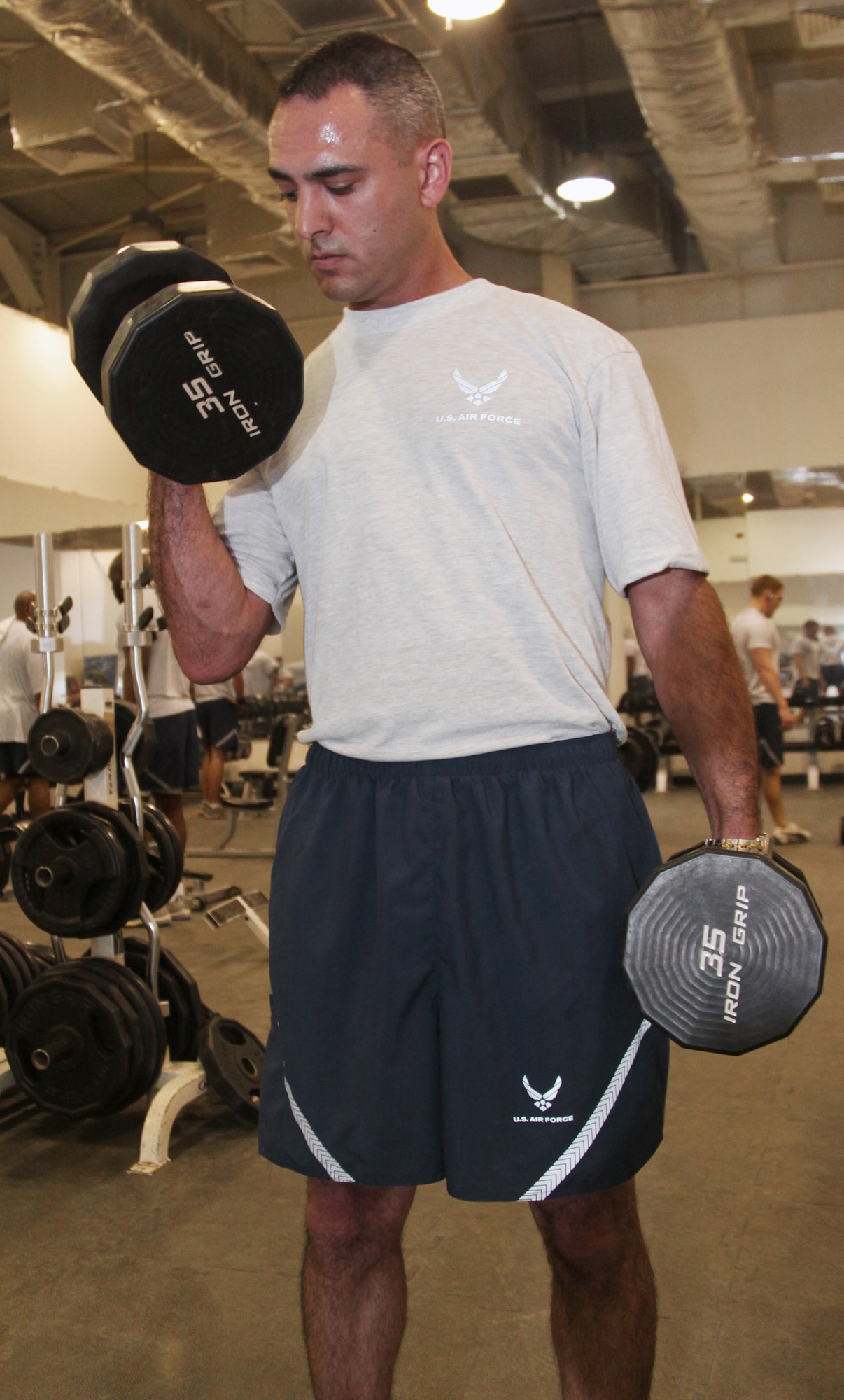 Senior Airman James Debiase puts the Air Force's modified physical training uniform to the test at the fitness center April 13 at Joint Base Balad, Iraq. Airman Debiase was selected to field-test the PT uniform while deployed here from Dyess Air Force Base, Texas, and to provide feedback to leadership at the end of April. Airman Debiase is a 332nd Expeditionary Civil Engineer Squadron emergency manager, and his hometown is Glastonbury, Conn. (U.S. Air Force photo/Tech. Sgt. Lionel Castellano) 
