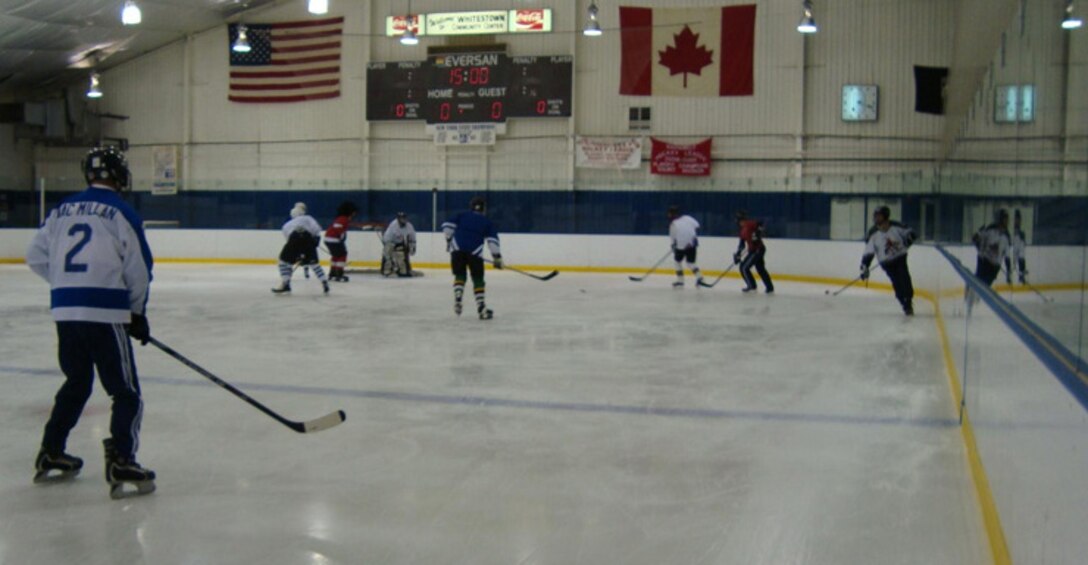 Members from the Northeast Air Defense Sector battle out a hockey game that pitted the Americans verses the Canadians Dec. 17. As a North American Aerospace Defense Command unit, NEADS is well-stocked with Canadian hockey players. Although the Canadians lost 3-7, they are eager for a re-match and continue sharpen their game by practicing at local hockey rinks. (Photo by Staff Sgt. Manon Thibeault, Canadian Forces).