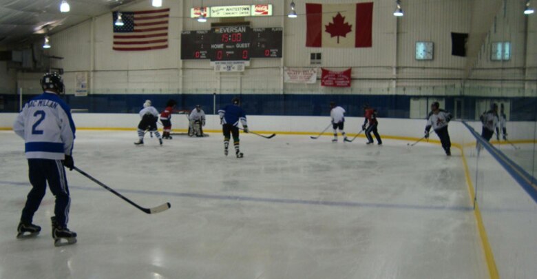 Members from the Northeast Air Defense Sector battle out a hockey game that pitted the Americans verses the Canadians Dec. 17. As a North American Aerospace Defense Command unit, NEADS is well-stocked with Canadian hockey players. Although the Canadians lost 3-7, they are eager for a re-match and continue sharpen their game by practicing at local hockey rinks. (Photo by Staff Sgt. Manon Thibeault, Canadian Forces).