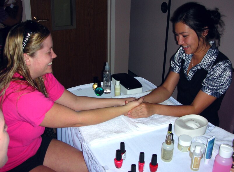 During the "Hearts Apart Spa Night," sponsored by the Tyndall Airman and Family Readiness Center, Mendia Cunningham, a nail technician with Serenity Spa at Bay Point, manicures Jamie Kaiser, spouse of a Tyndall member currently serving a tour in Korea. Among the activities of the night, spouses who participated were able to receive manicures, make-overs, pedicures, waxing and other beautification/relaxation activites. All services were donated free-of-charge by businesses from the area to the more than 50 spouses present. (U.S. Air Force photo/SSgt Joshua Stevens)