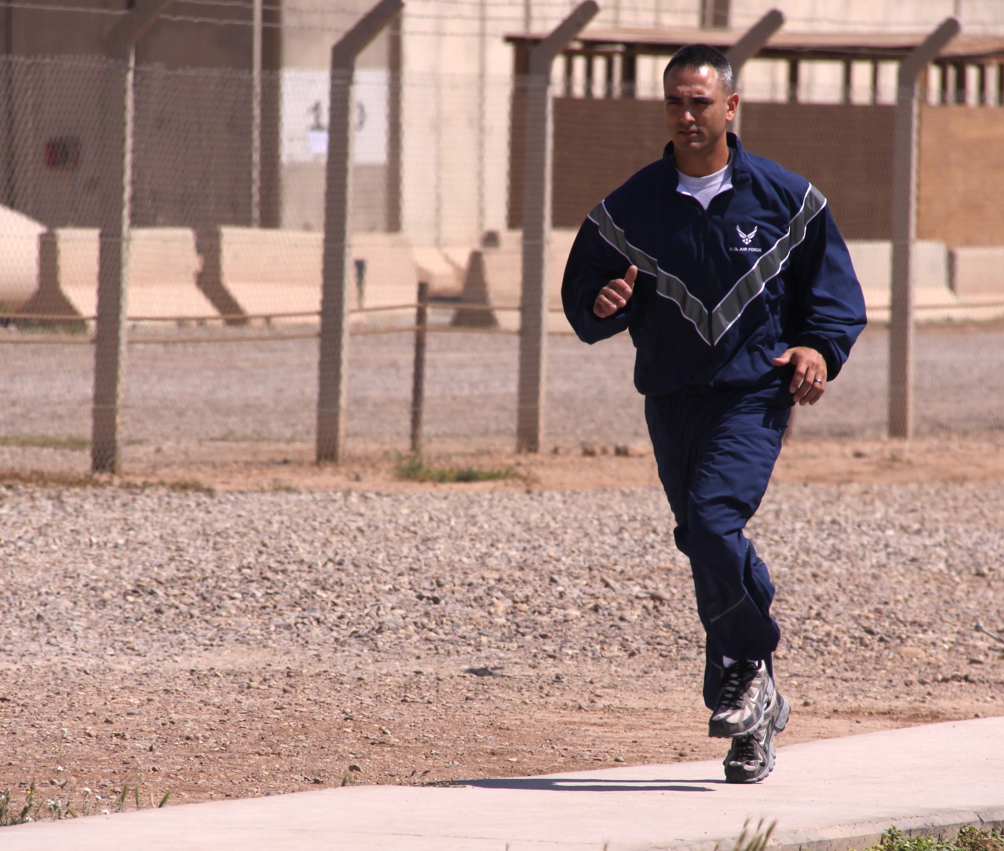 JOINT BASE BALAD, Iraq -- Senior Airman James Debiase, 332nd Expeditionary Civil Engineer Squadron emergency manager, goes for a run around JBB here April 13 to try out the Air Force's modified physical training uniform that is under consideration to replace the current PT uniform. Airman Debiase was selected to field-test the PT uniform while deployed here from Dyess Air Force Base, Texas, and to provide feedback to leadership at the end of April.  Sergeant Debiase's hometown is Glastonbury, Conn. (U.S. Air Force photo/Tech. Sgt. Lionel Castellano)   