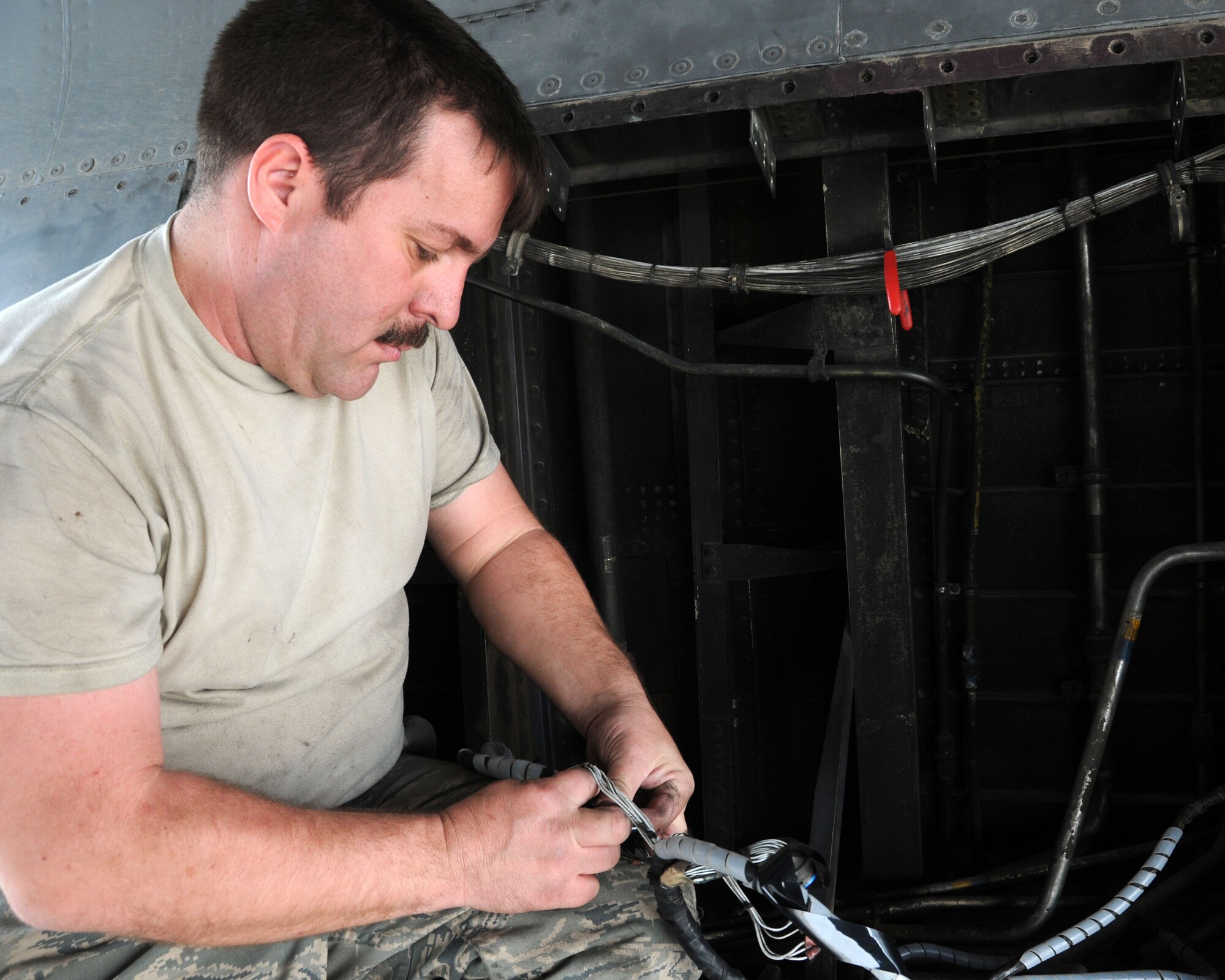 SOUTHWEST ASIA -- Senior Airman Leonard McVey, 386th Expeditionary Aircraft Maintenance Squadron, retapes wires after verifying that none of the needed to be replaced at an air base in Southwest Asia, April 11. The wires are checked to ensure that during flight the they don't rub against the aircraft and start a fire. Airman McVey is currently deployed from Dyess Air Force Base, Texas and is originally from Ft. Pierce, Fla. (U.S. Air Force photo/Senior Airman Courtney Richardson)