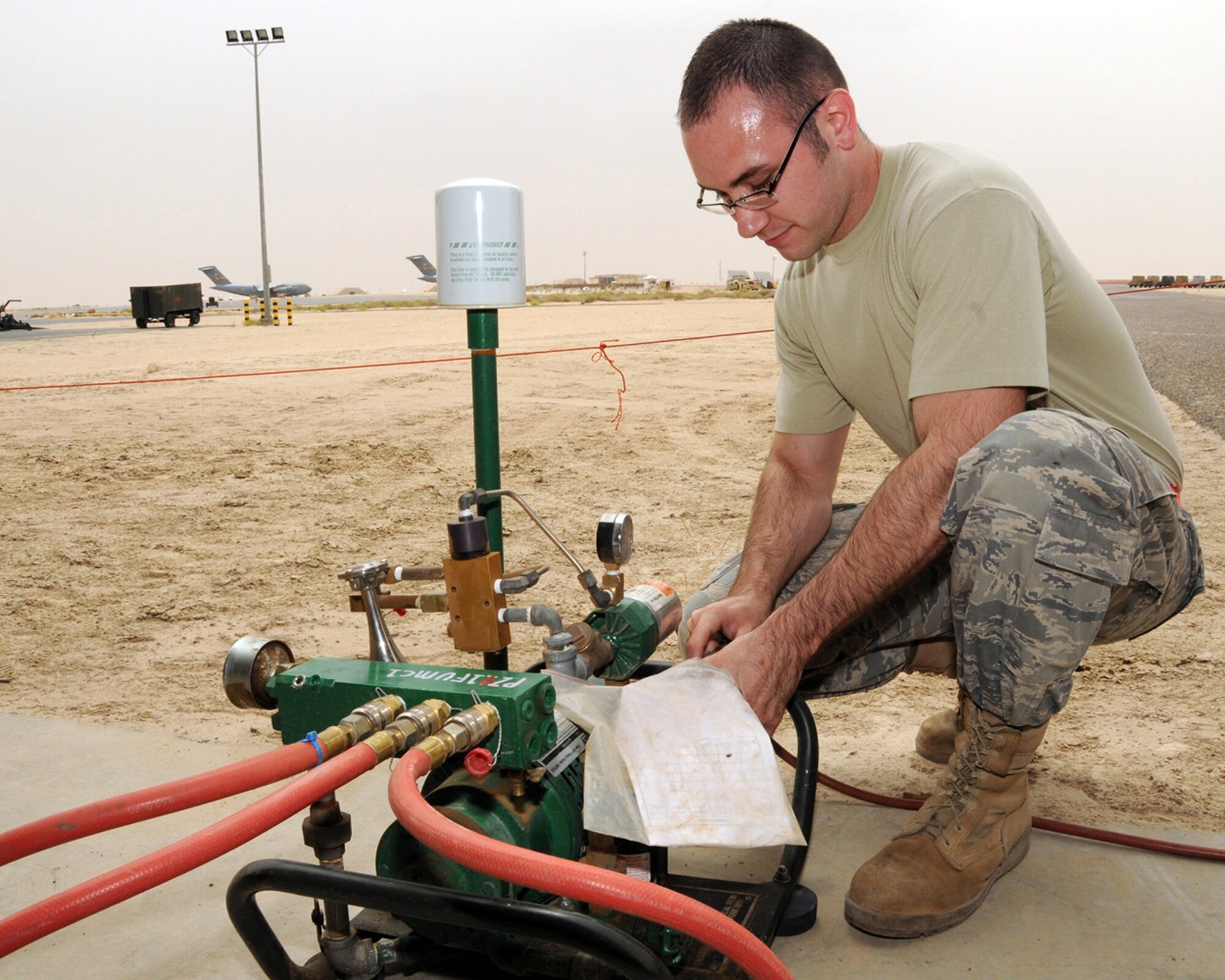 SOUTHWEST ASIA -- Senior Airman Aron Aldridge, 386th Expeditionary Maintenance Squadron fuels technician, hooks up a rhine air pump before gearing up to check an aircraft fuel tank for leaks at an air base in Southwest Asia, April 11. A rhine air pump is a forced air breathing system that allows up to four oxygen masks to be used at once. Airman Aldridge is currently deployed from Yokota Air Base, Japan, and is originally from Indiana. (U.S. Air Force photo/ Senior Airman Courtney Richardson)