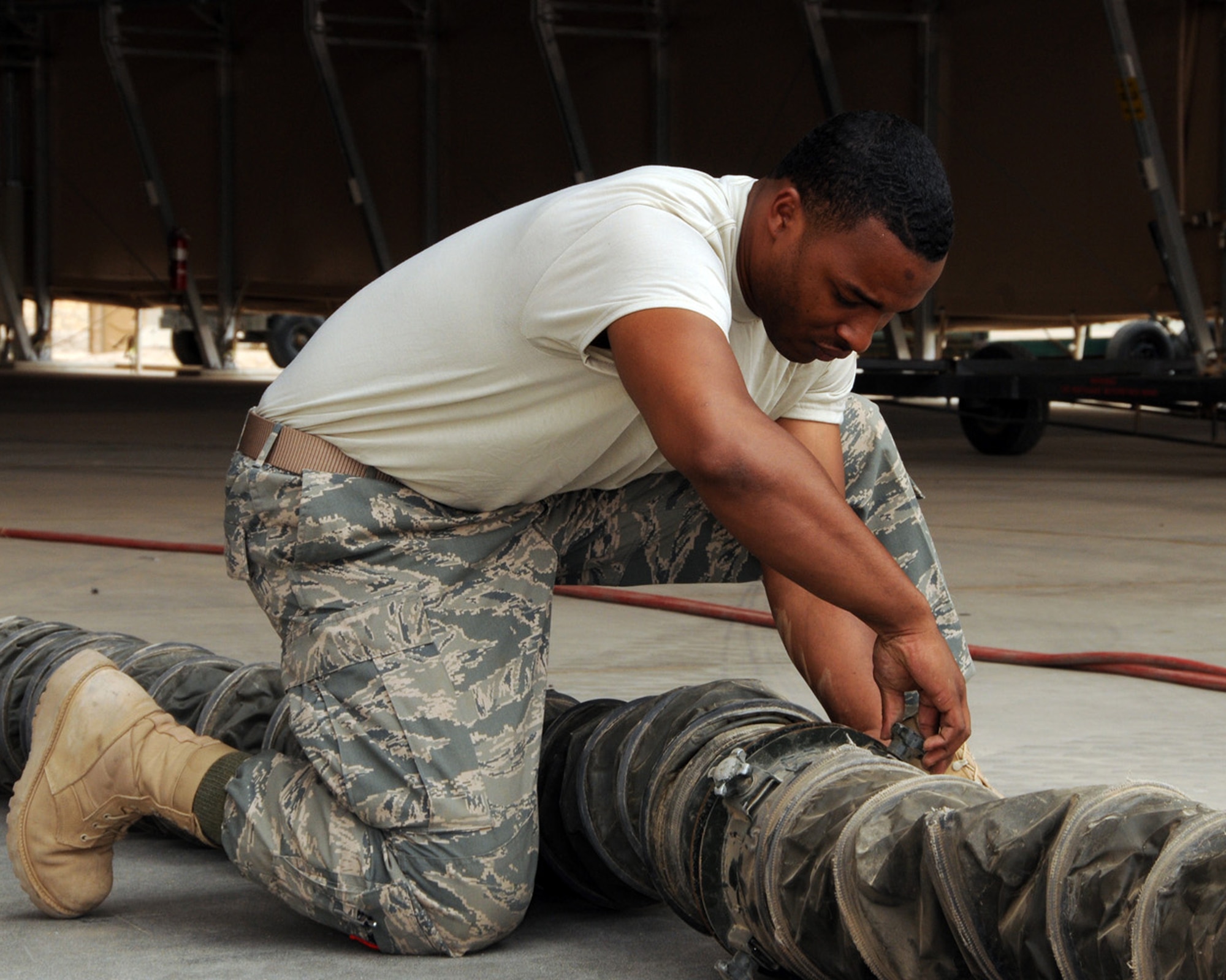 SOUTHWEST ASIA -- Staff Sgt Korvarsie Hicks, 386th Expeditionary Maintenance Squadron fuels technician, attaches oxygen hoses before working on an aircraft fuel tank at an air base in Southwest Asia, April 11. Before working on the fuel tanks, Airmen must wear respirators to prevent inhalation of fuel vapors. Sergeant Hicks is deployed from Ramstein Air Base, Germany, and is originally from Detroit. (U.S. Air Force photo/Senior Airman Courtney Richardson)