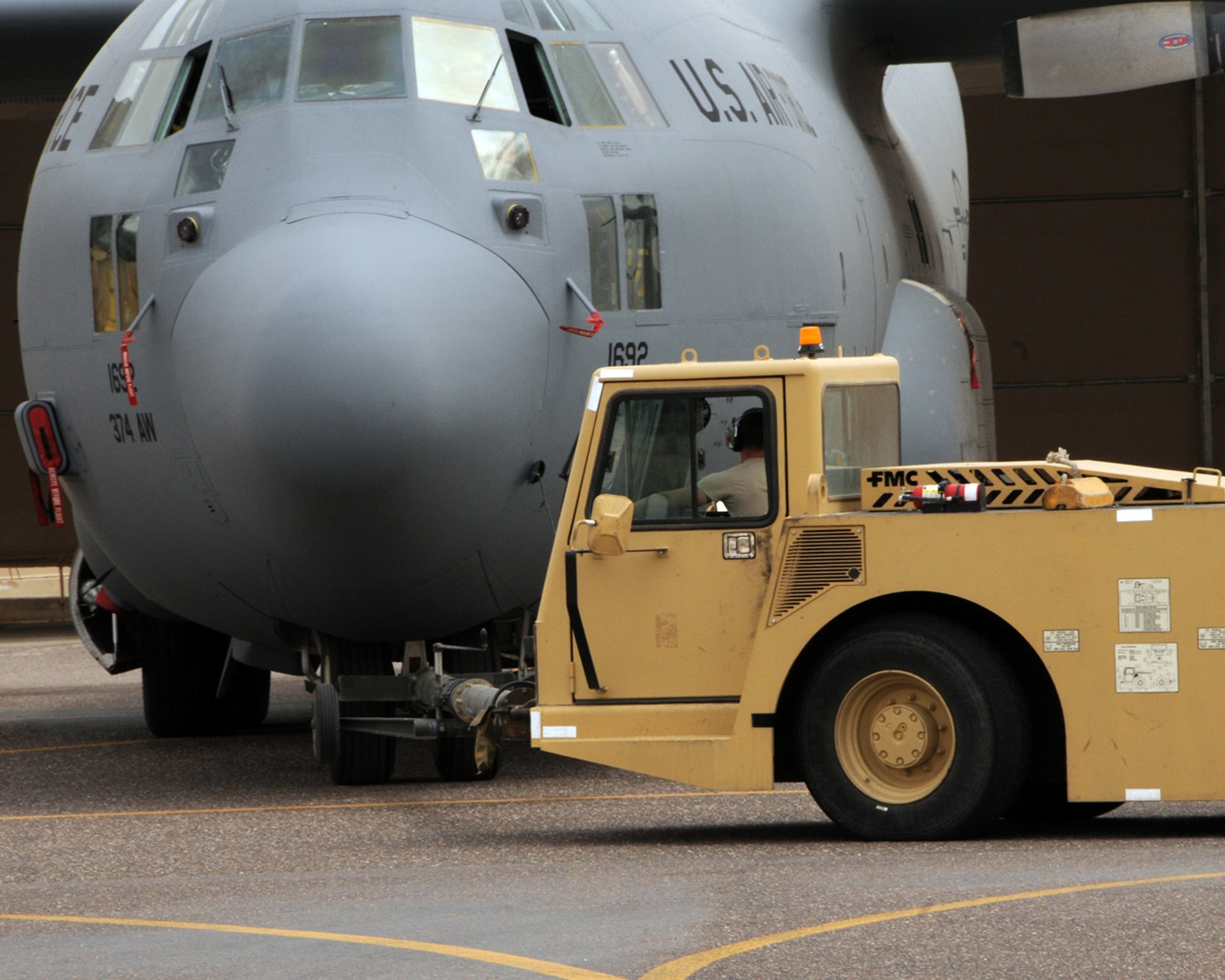 SOUTHWEST ASIA -- An Airman from the 386th Expeditionary Aircraft Maintenance Squadron, backs a C-130 aircraft into hangar for fuel tank maintenance at an air base in Southwest Asia, April 11. Before maintenance can begin on an aircraft's fuel system, the aircraft must be moved into the hangar for isolation, weather and personal safety. (U.S. Air Force photo/ Senior Airman Courtney Richardson)