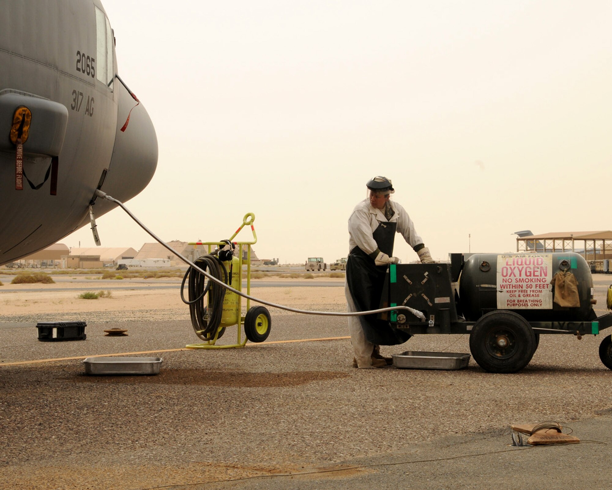SOUTHWEST ASIA -- Senior Airman Rebecca Roa, 386th Expeditionary Aircraft Maintenance Squadron crew chief, watches as liquid oxygen is pumped into a C-130 aircraft at an air base in Southwest Asia, April 11. Once the liquid oxygen is serviced into the aircraft, it is converted by the aircraft system into a breathable, gaseous state for aircrew use. Airman Roa is currently deployed from Dyess Air Force Base, Texas and is originally from Eagle Point, Ore. (U.S. Air Force photo/ Senior Airman Courtney Richardson)