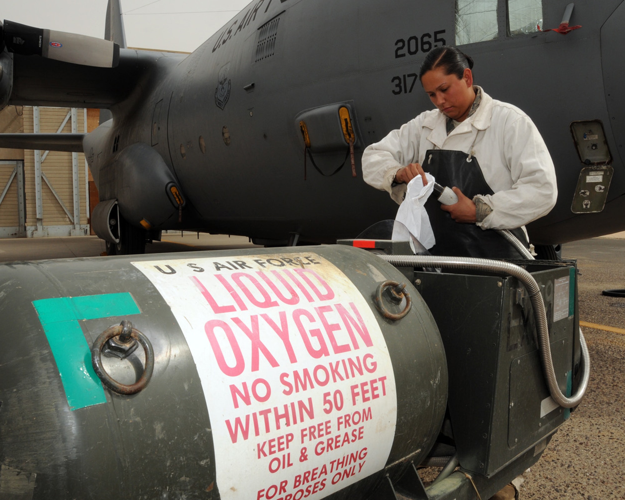 SOUTHWEST ASIA -- Senior Airman Rebecca Roa, 386th Expeditionary Aircraft Maintenance Squadron crew chief, cleans the liquid oxygen nozzle before attaching it to a C-130 aircraft at an air base in Southwest Asia, April 11. The liquid oxygen is serviced into the aircraft after flight and, when needed, it is converted by the aircraft system into a breathable, gaseous state for aircrew use. Airman Roa is currently deployed from Dyess Air Force Base, Texas and is originally from Eagle Point, Ore. (U.S. Air Force photo/ Senior Airman Courtney Richardson)