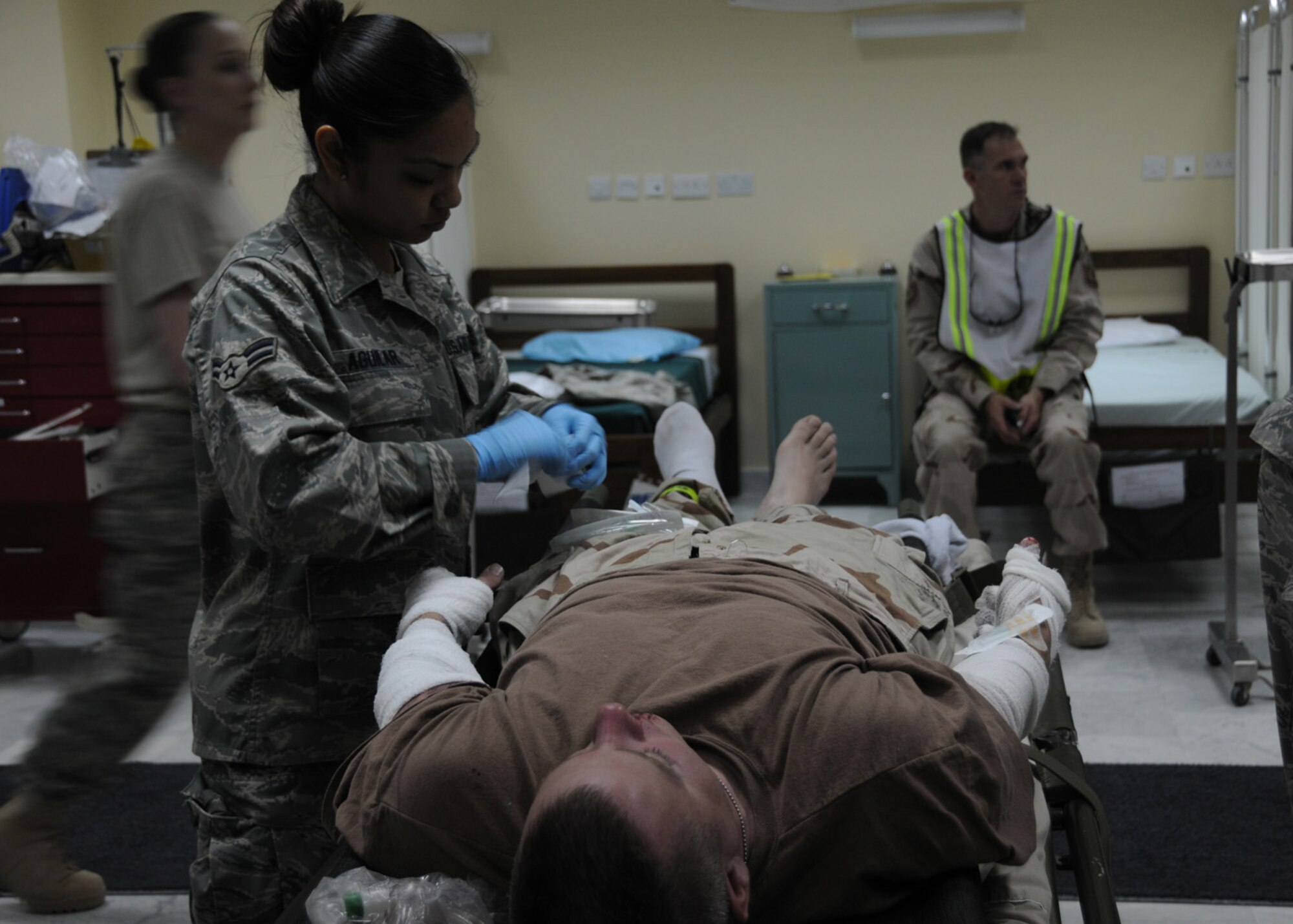 SOUTHWEST ASIA -- Airman 1st Class Alyssa Aguilar, 386th Expeditionary Medical Group, secures bandages on a simulated patient during a Base Response and Readiness Exercise at an air base in Southwest Asia, April 13. In the event of a real-world emergency, the patients are given initial treatment on the scene and then transferred to the nearest medical facility. Airman Aguilar is currently deployed from Wright- Patterson Air Force Base, Ohio, and is originally from Sacramento, California. (U.S. Air Force photo/ Senior Airman Courtney Richardson)