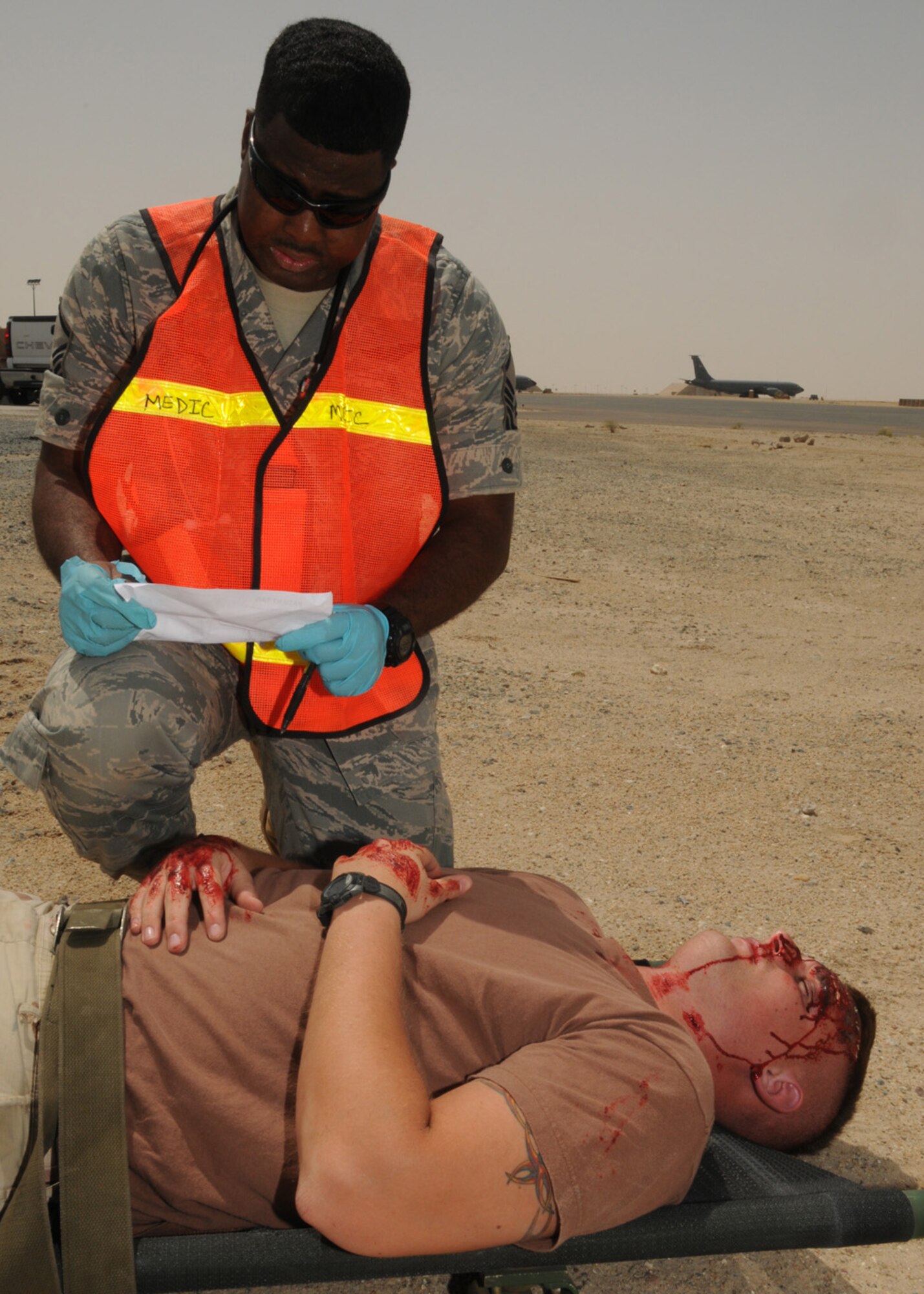 SOUTHWEST ASIA -- Master Sgt. Kevin Mathews, 386th Expeditionary Medical Group, assesses a victim during a Base Response and Readiness Exercise at an air base in Southwest Asia, April 13. During the exercise, the patients are given a printout of their wounds and a description of how they are supposed to act during the exercise, and the emergency responders treat the victim accordingly. Sergeant Mathews is currently deployed from Ramstein Air Base, Germany, and is originally from Atlanta. (U.S. Air Force photo/ Senior Airman Courtney Richardson)